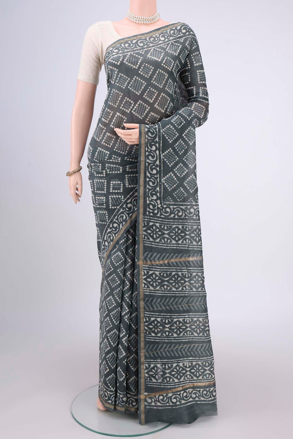 Grey Maheshwari Silk Cotton Saree with Batik Print on the body and Zari Border.  displayed on a mannequin