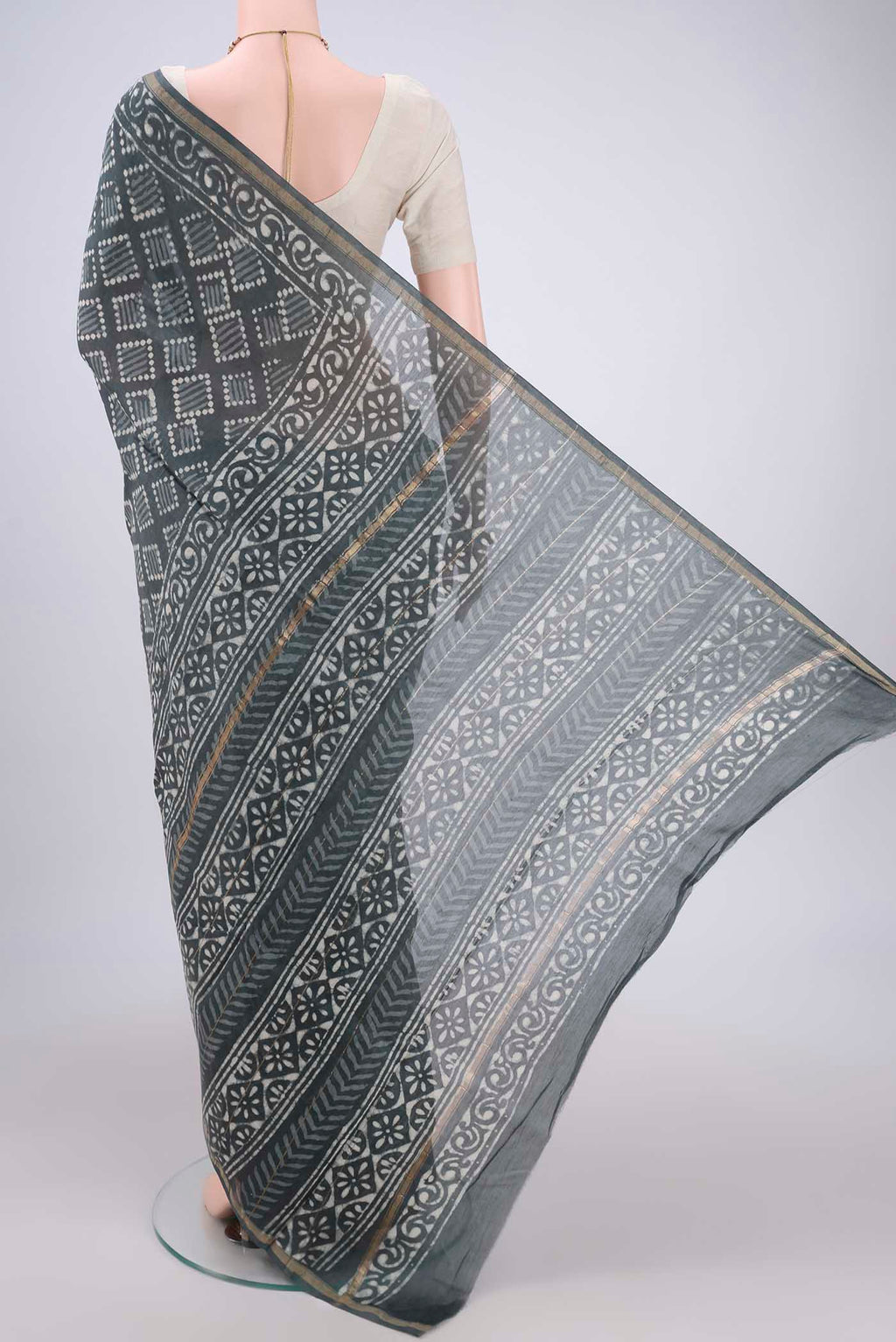Flat view of Grey Maheshwari Silk Cotton Saree with Batik Print on the body and Zari Border. 