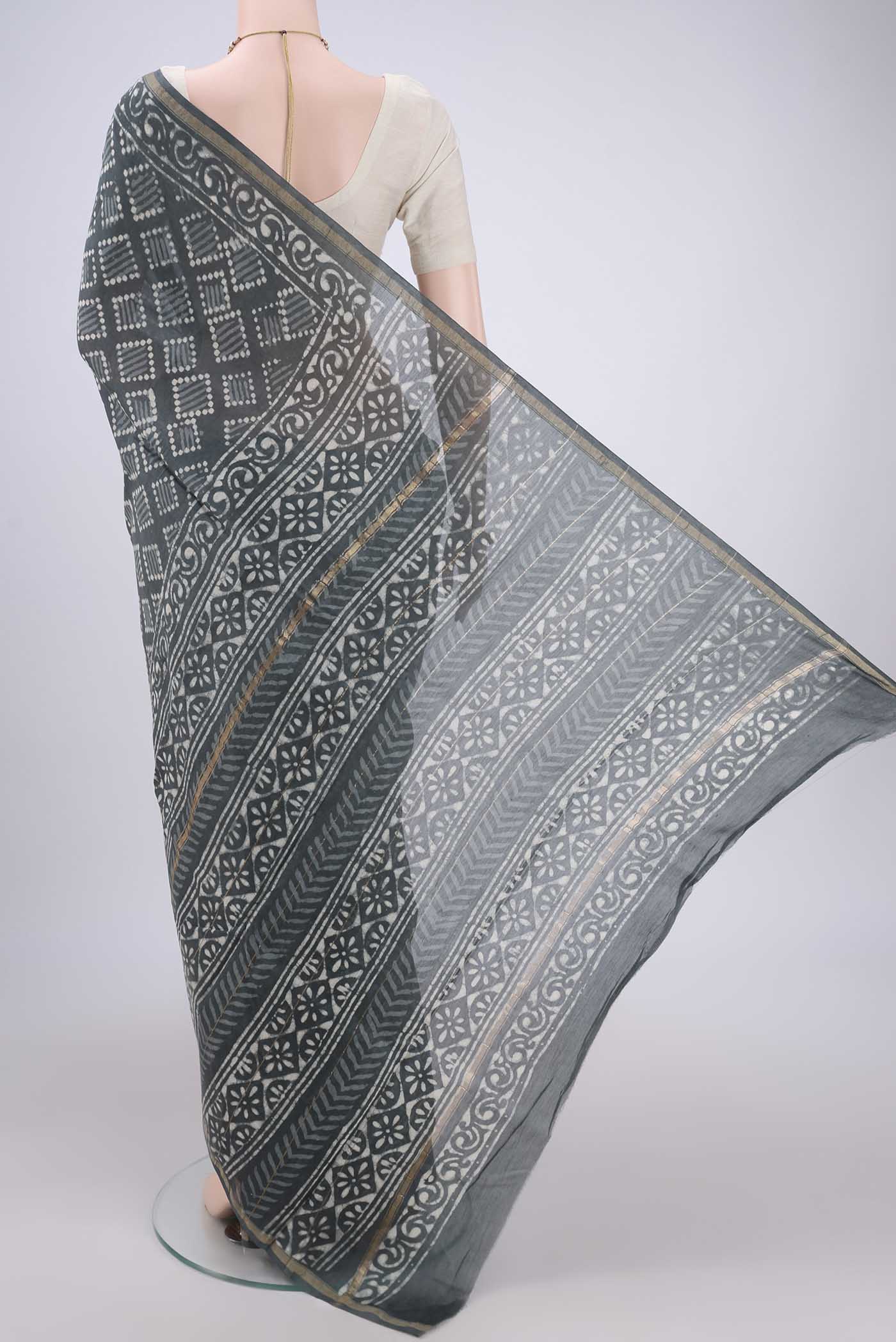 Flat view of Grey Maheshwari Silk Cotton Saree with Batik Print on the body and Zari Border. 