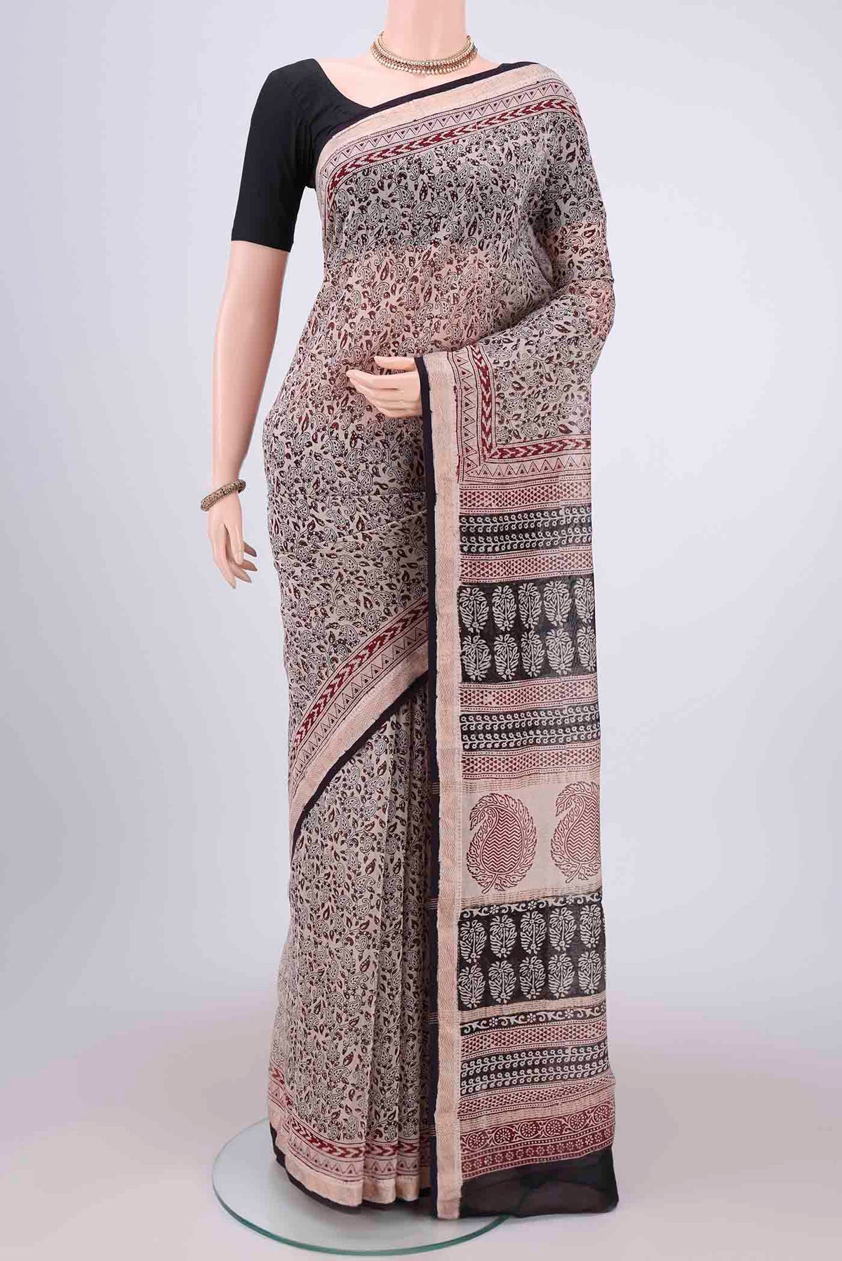 Beige Maheshwari Silk Cotton Saree with Printed design on the body and Zari Border.  displayed on a mannequin