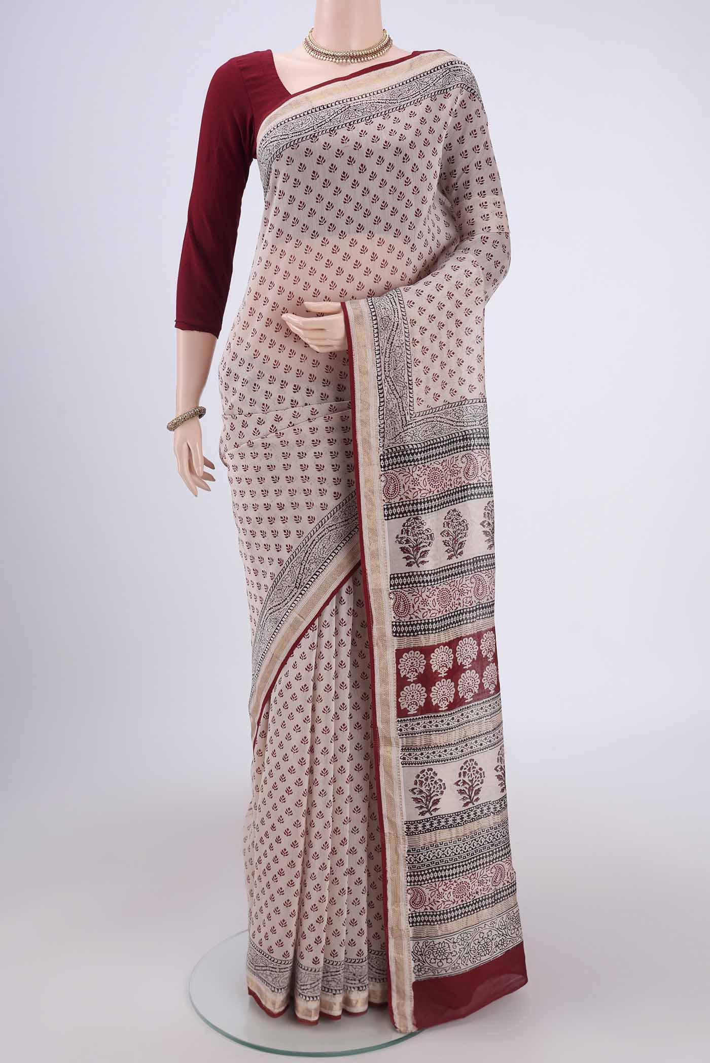 Beige Maheshwari Silk Cotton Saree with Printed design on the body and Zari Border.  displayed on a mannequin