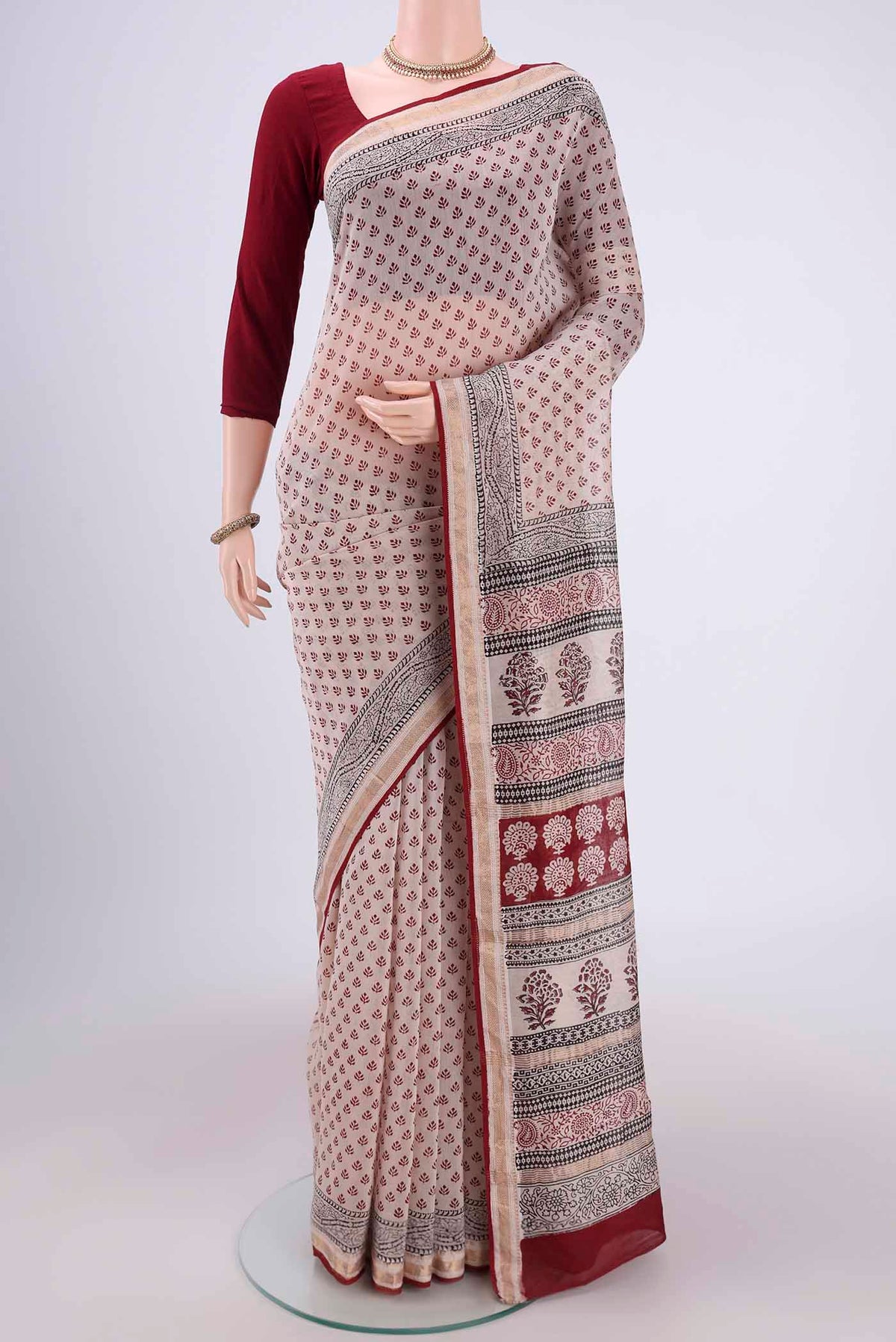 Beige Maheshwari Silk Cotton Saree with Printed design on the body and Zari Border.  displayed on a mannequin