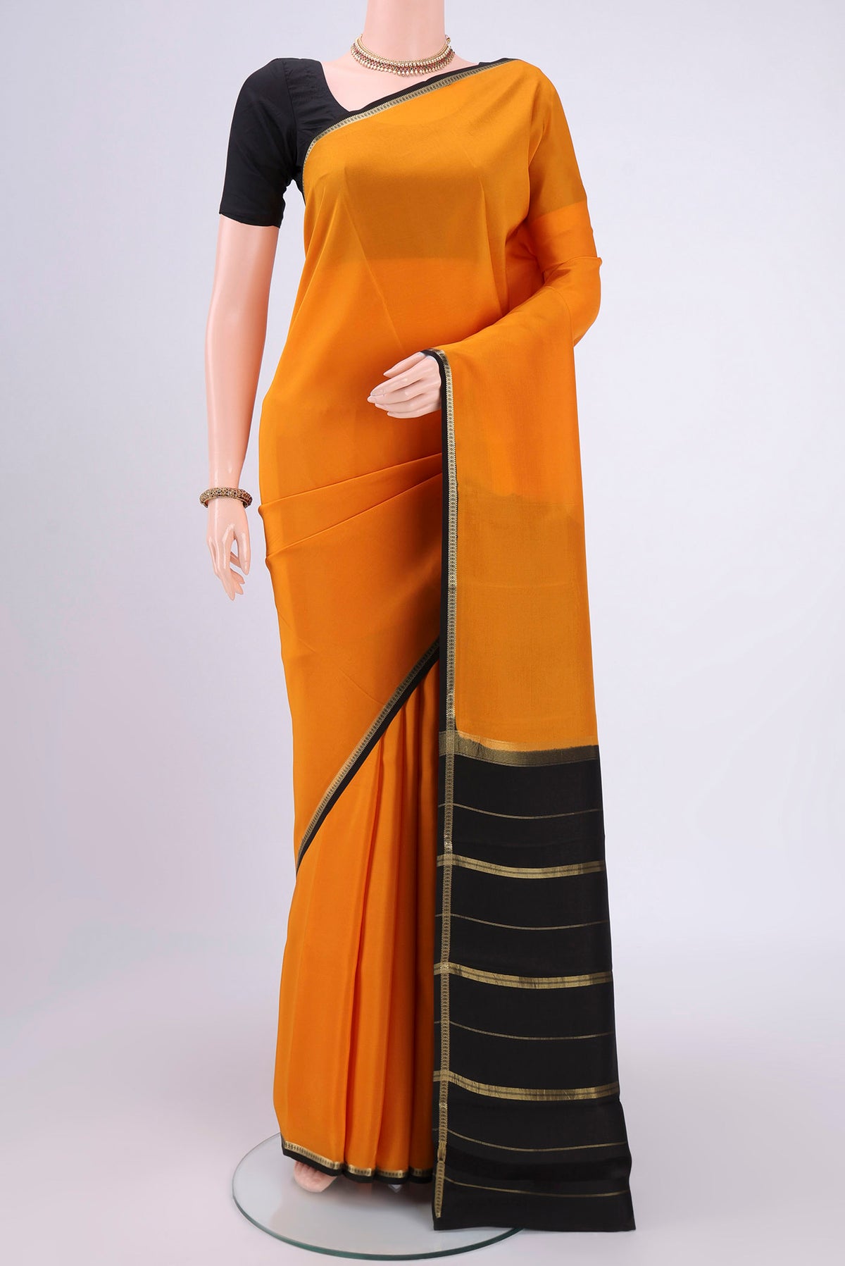 Pure Silk Pure Zari Mustard Mysore Crepe Saree with Plain Body and Zari Border.  displayed on a mannequin