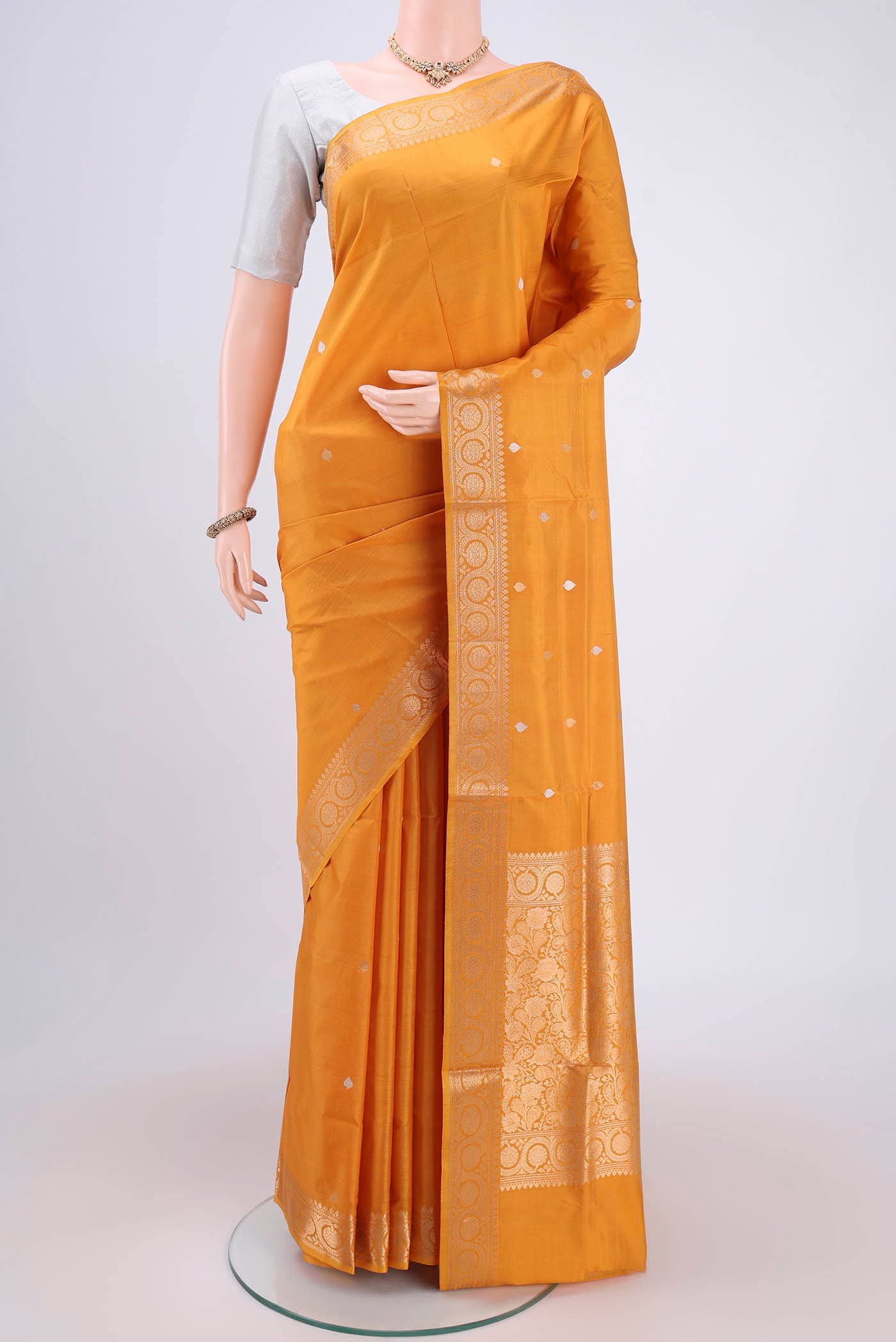 Yellow Soft Silk Saree with Zari Butta on the body and Zari Border.  displayed on a mannequin