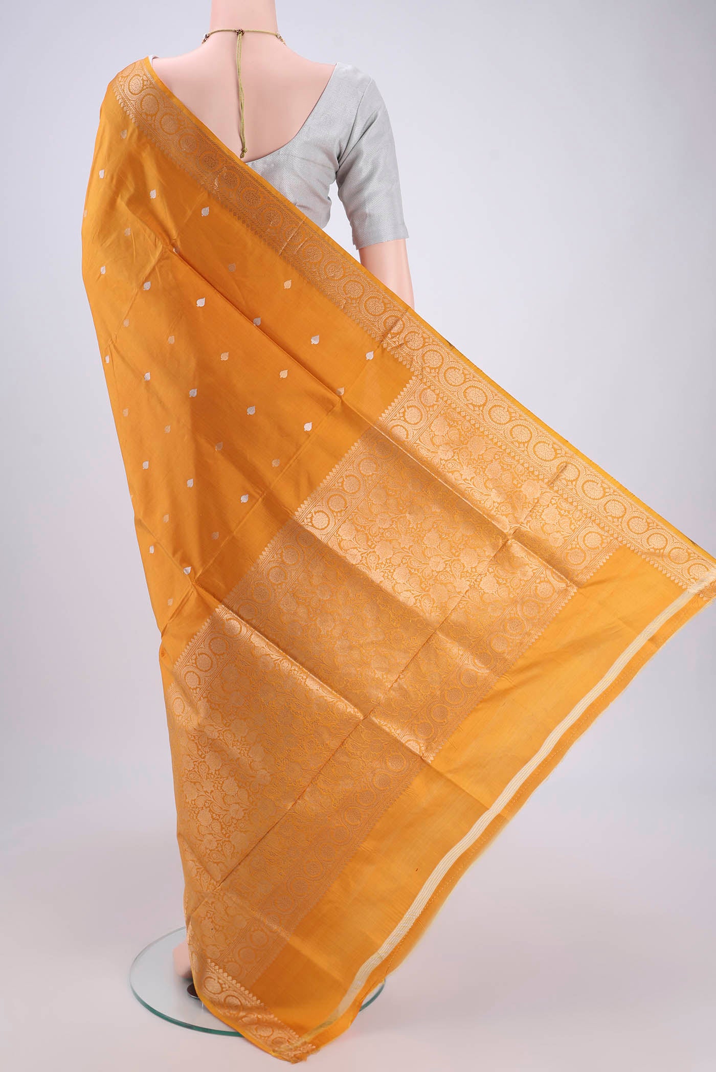 Flat view of Yellow Soft Silk Saree with Zari Butta on the body and Zari Border. 