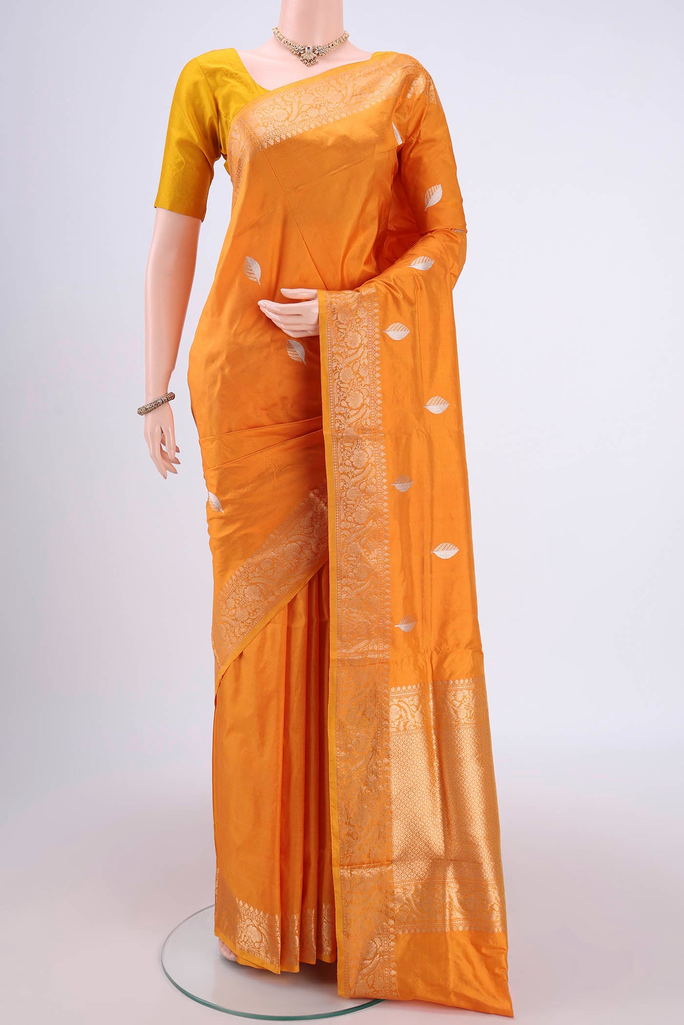 Orange Banarasi Katan Silk Saree with Zari Butta on the body and Zari Border.  displayed on a mannequin