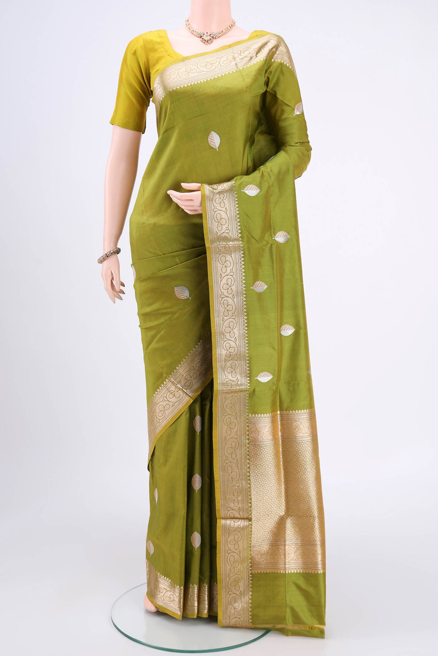 Light Green Banarasi Katan Silk Saree with Zari Butta on the body and Zari Border.  displayed on a mannequin