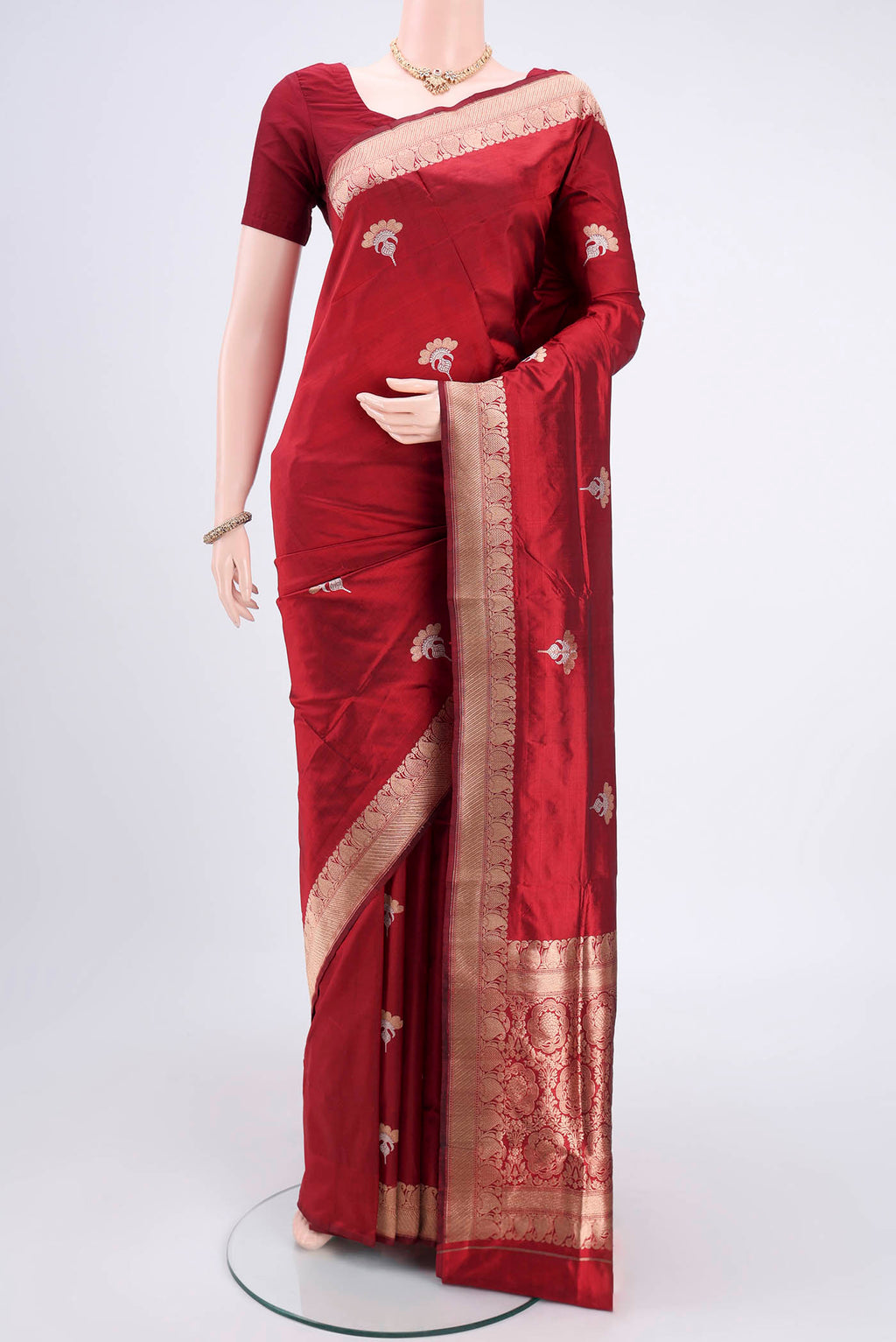 Maroon Banarasi Katan Silk Saree with Zari Butta on the body and Zari Border.  displayed on a mannequin