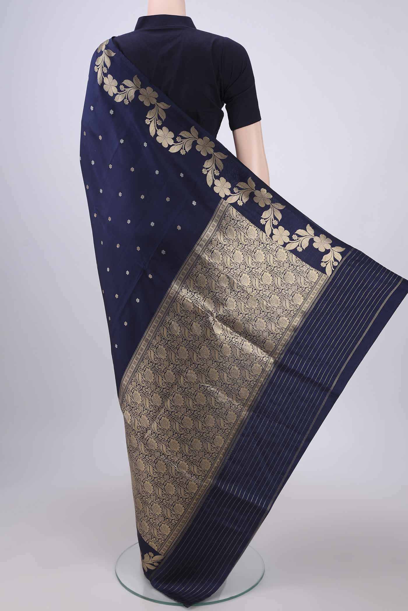 Flat view of Navy Blue Banarasi Katan Silk Saree with Zari Butta on the body and Zari Border. 