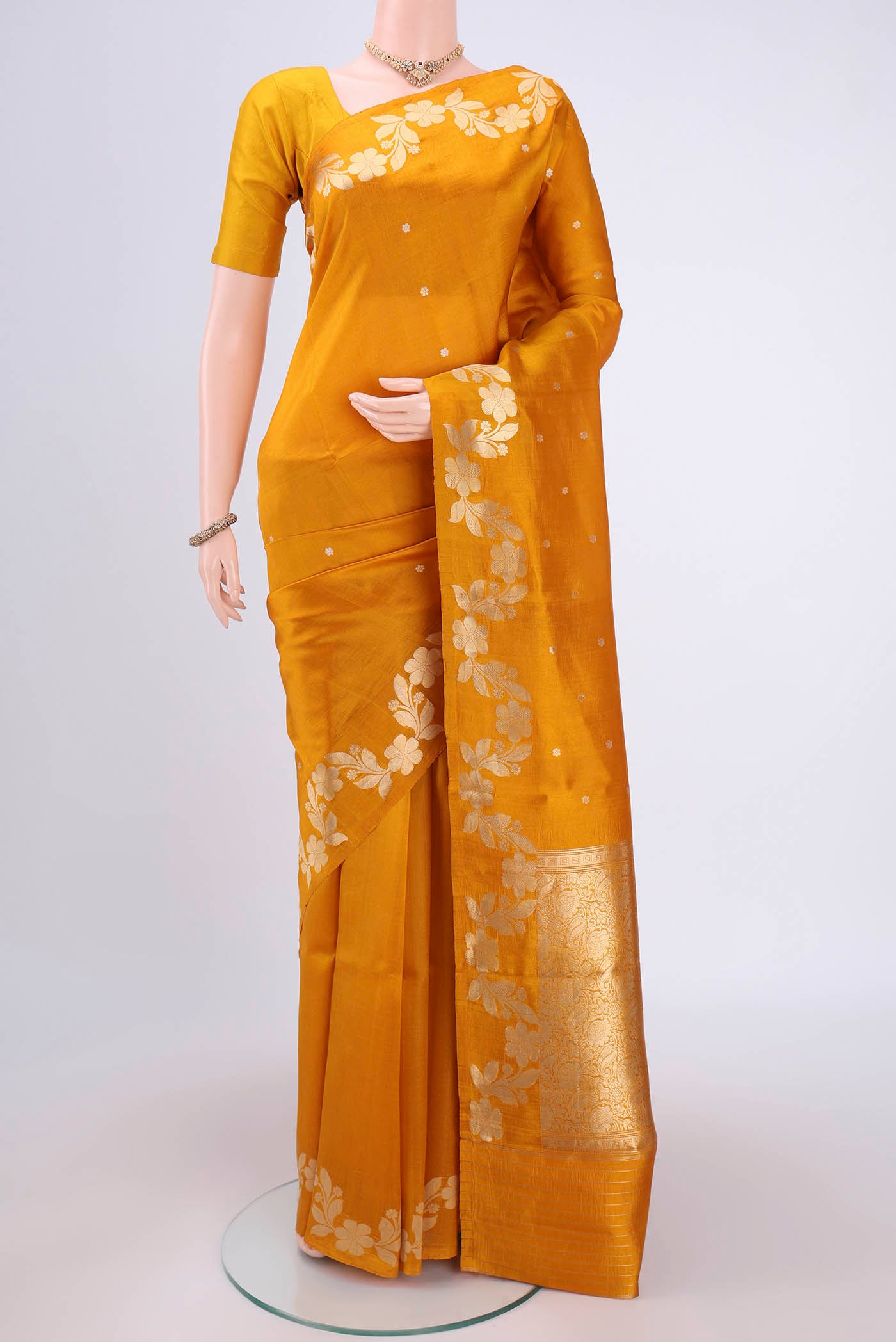 Mustard Banarasi Katan Silk Saree with Zari Butta on the body and Zari Border.  displayed on a mannequin
