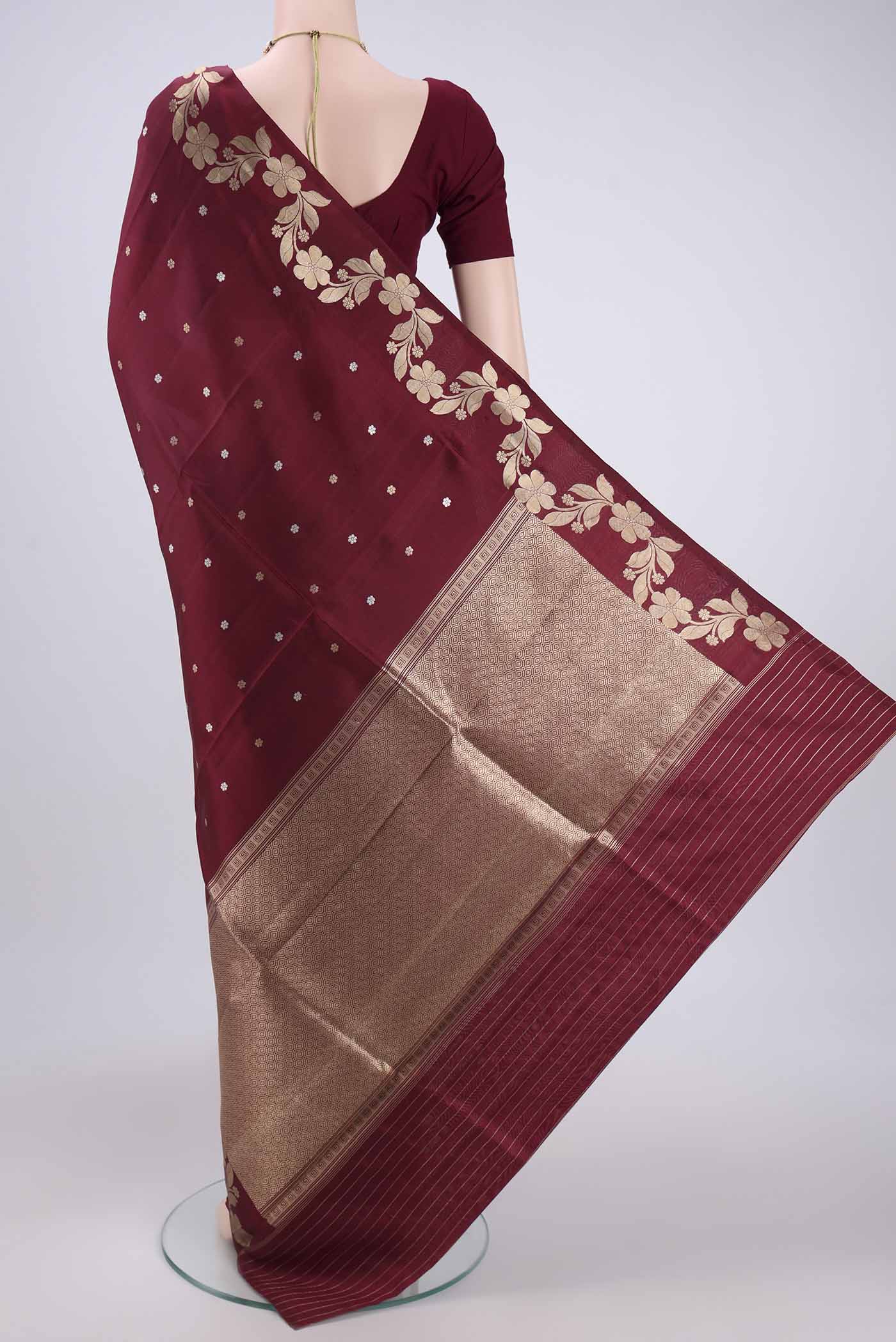 Flat view of Maroon Banarasi Katan Silk Saree with Zari Butta on the body and Zari Border. 