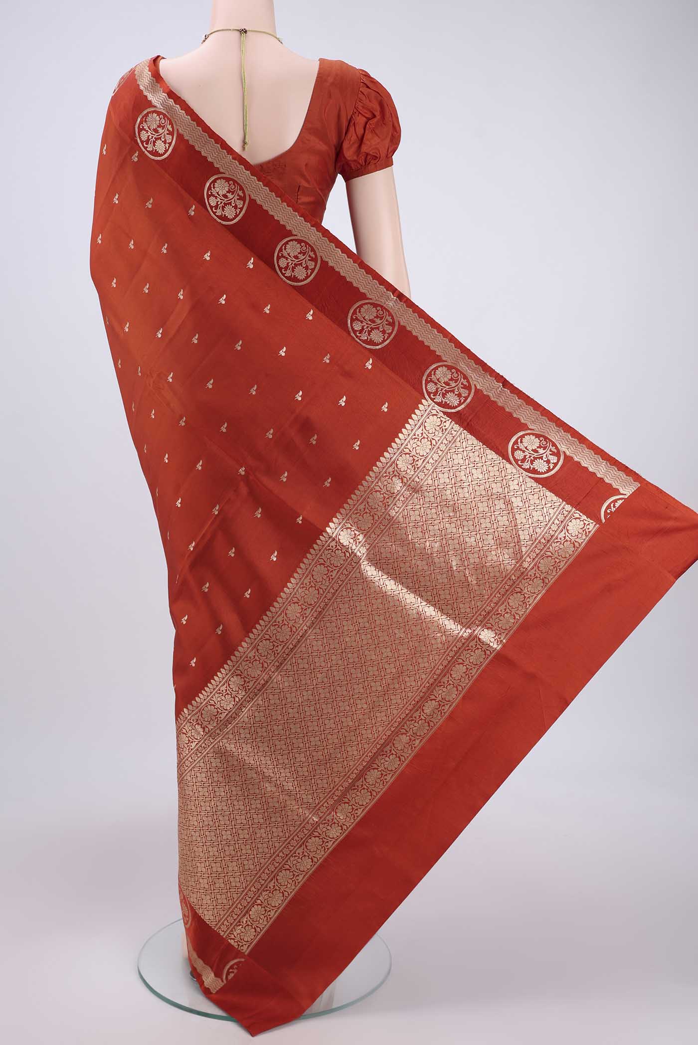 Flat view of Rust Banarasi Katan Silk Saree with Zari Butta on the body and Zari Border. 