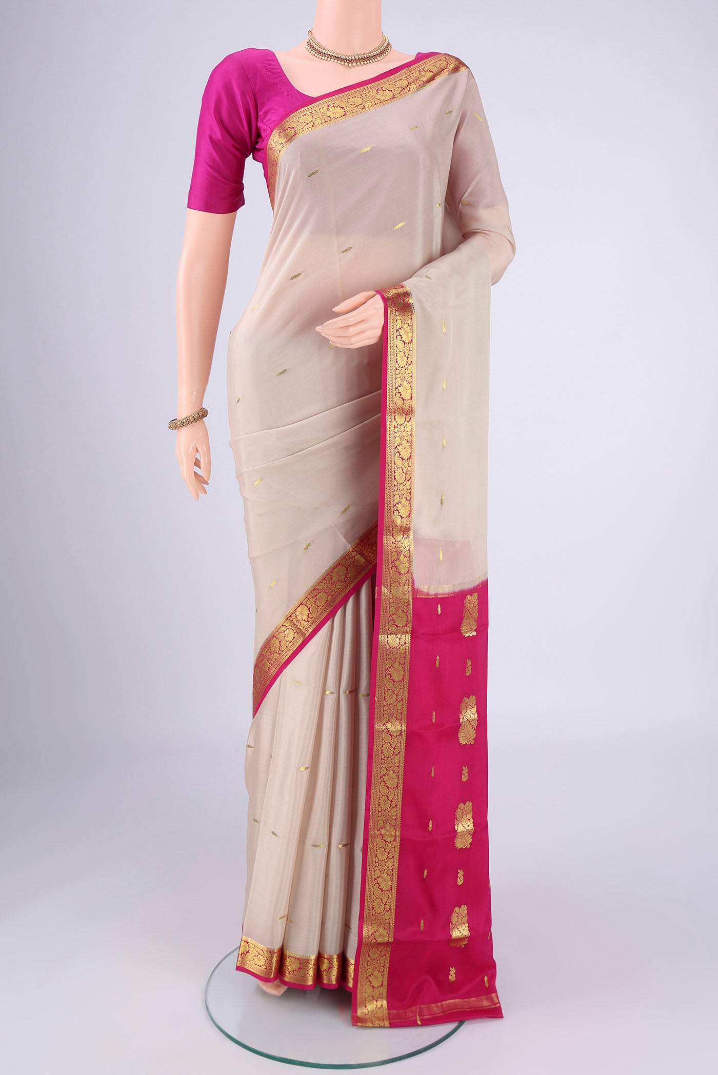 Off White Mysore Crepe Saree with Zari Butta on the body and Zari Border.  displayed on a mannequin