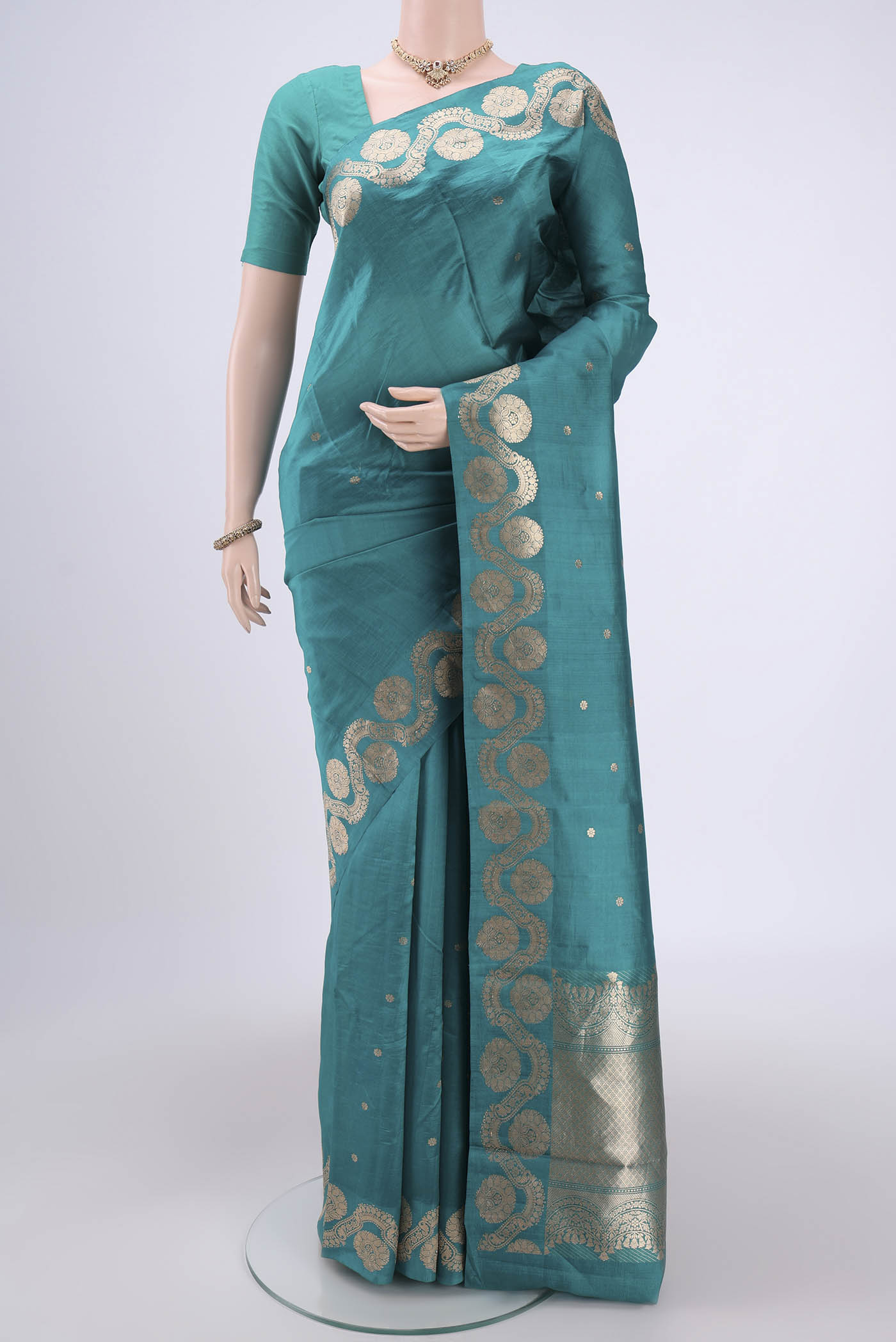 Turquoise Banarasi Katan Silk Saree with Zari Butta on the body and Zari Border.  displayed on a mannequin