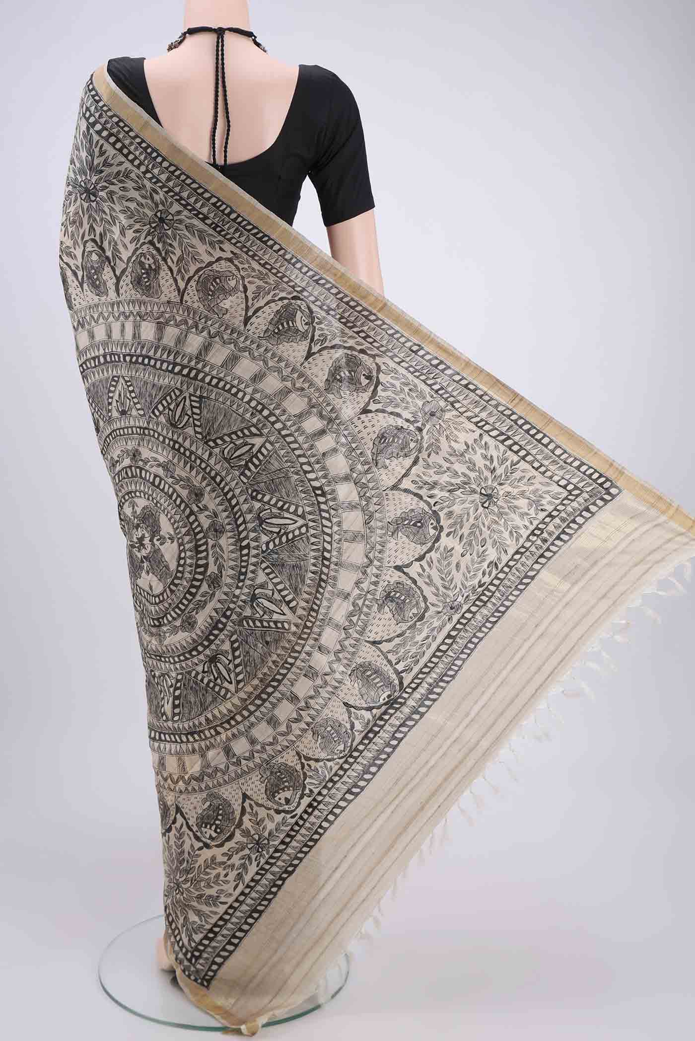 Flat view of Beige Tussar Silk Saree with Printed design on the body and Zari Border. 
