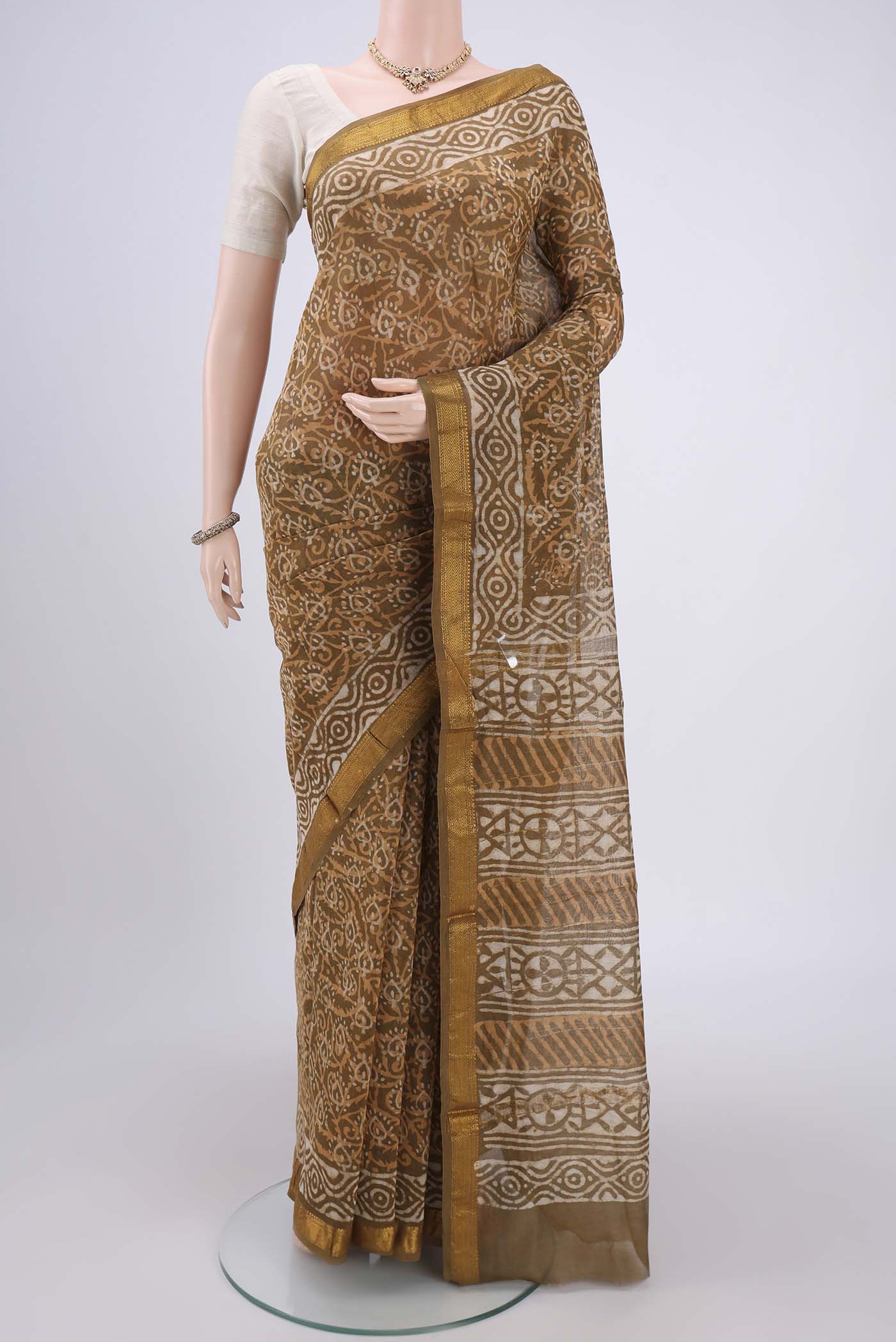 Mustard Maheshwari Silk Cotton Saree with Batik Print on the body and Zari Border.  displayed on a mannequin