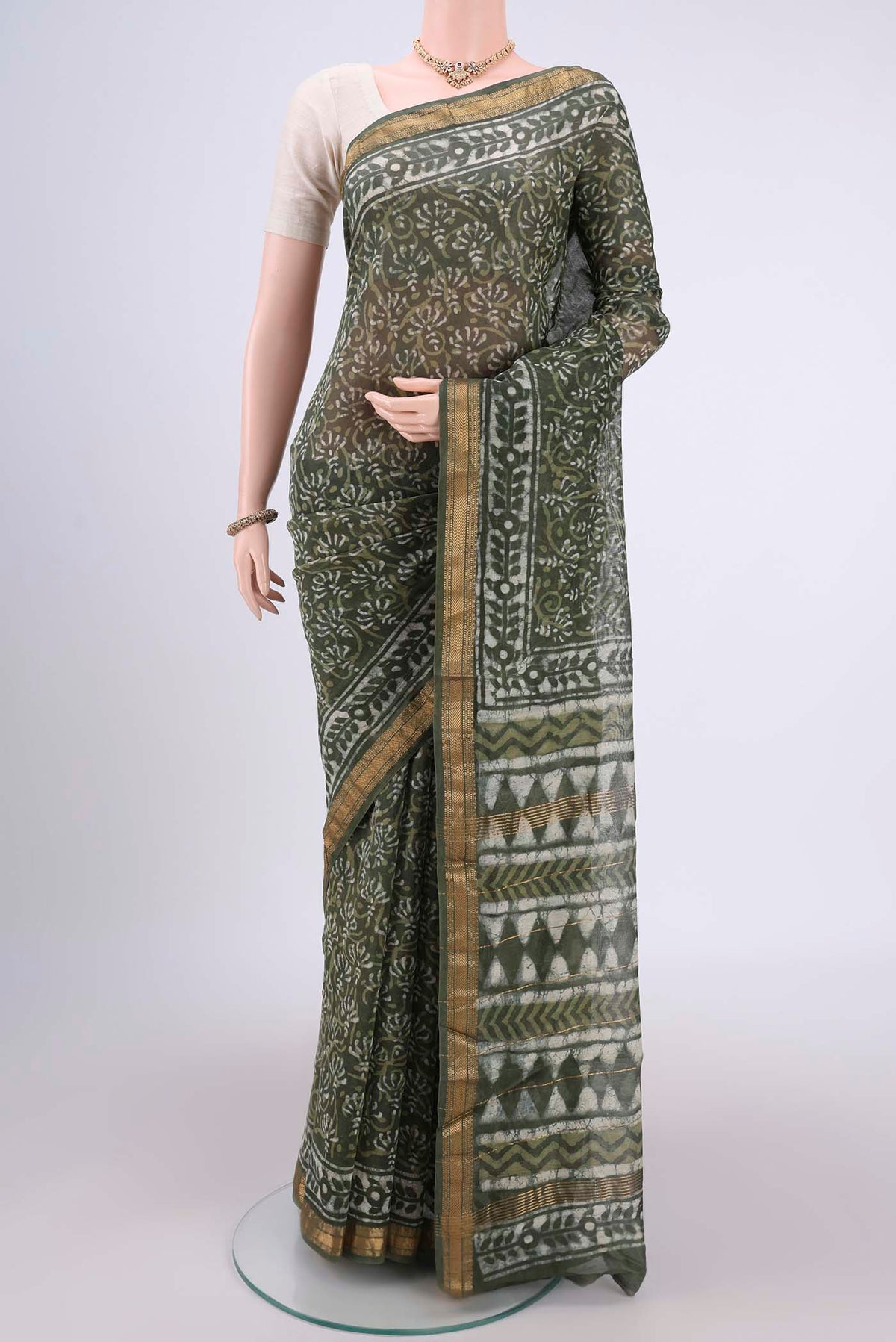 Olive Green Maheshwari Silk Cotton Saree with Batik Print on the body and Zari Border.  displayed on a mannequin