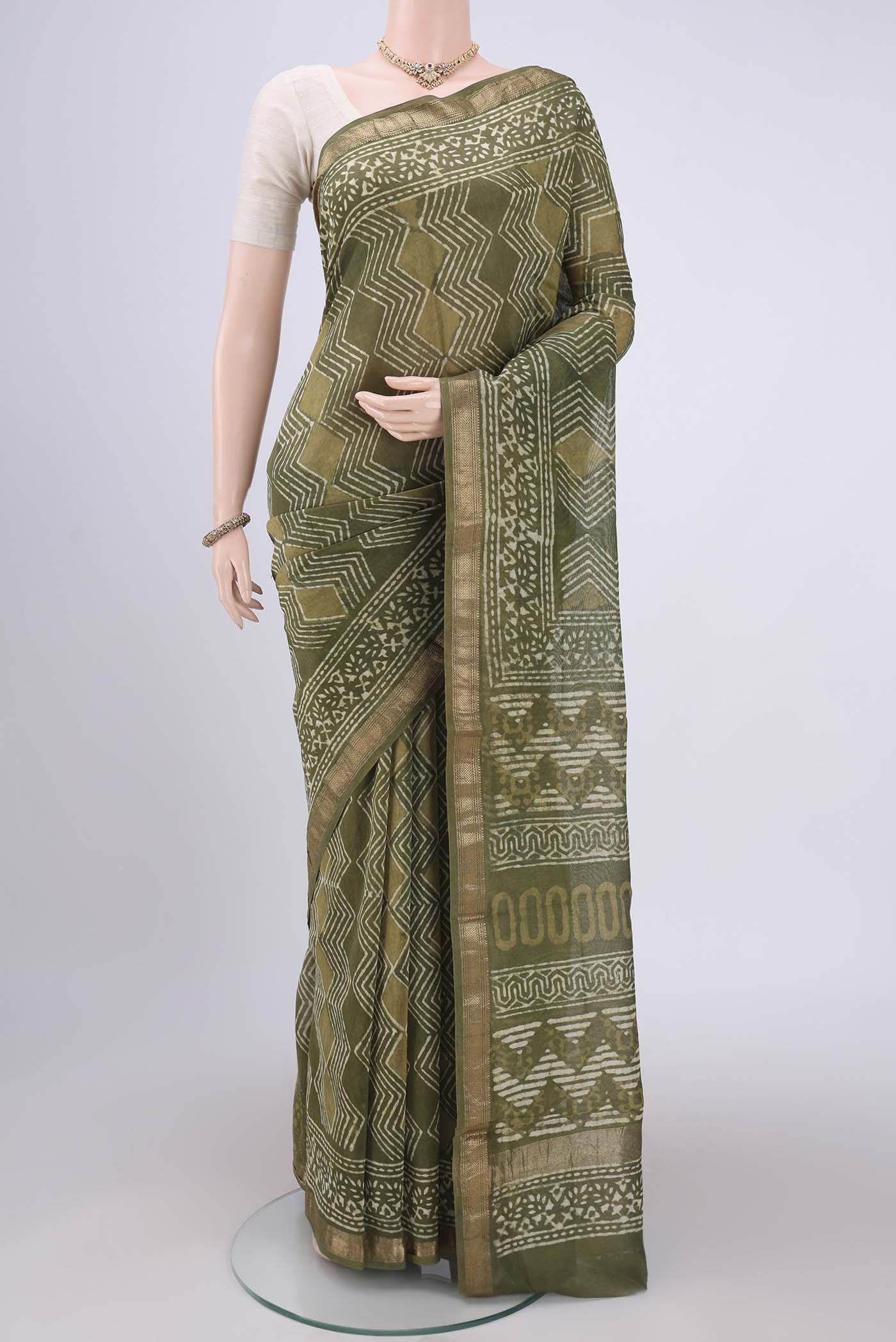 Olive Green Maheshwari Silk Cotton Saree with Batik Print on the body and Zari Border.  displayed on a mannequin