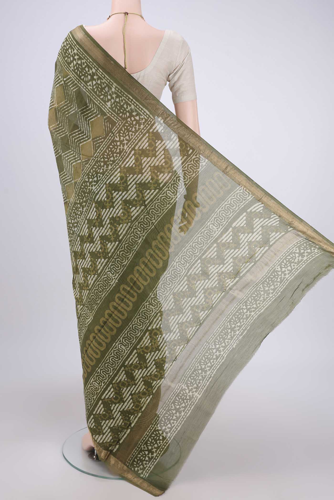 Flat view of Olive Green Maheshwari Silk Cotton Saree with Batik Print on the body and Zari Border. 