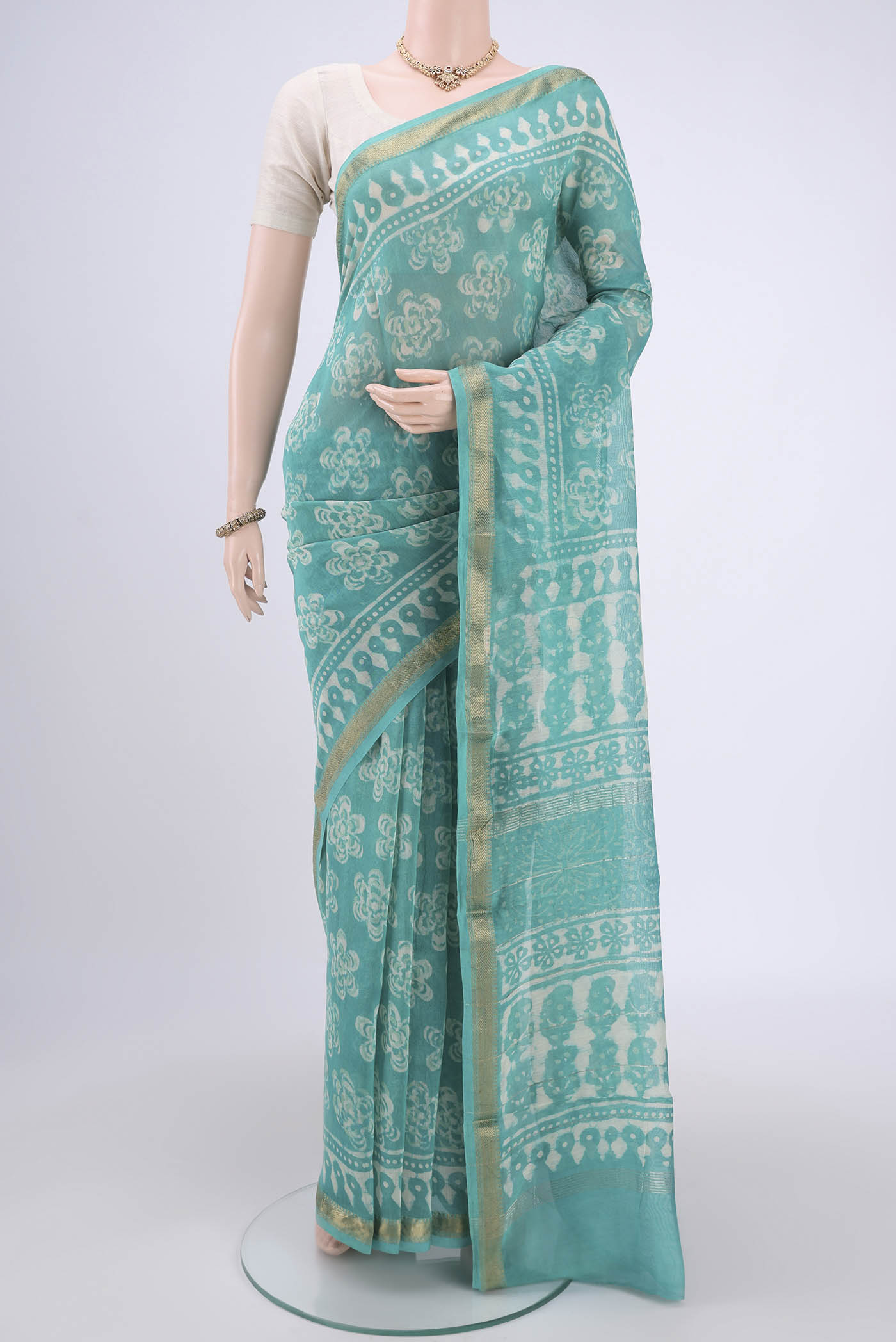 Light Green Maheshwari Silk Cotton Saree with Batik Print on the body and Zari Border.  displayed on a mannequin