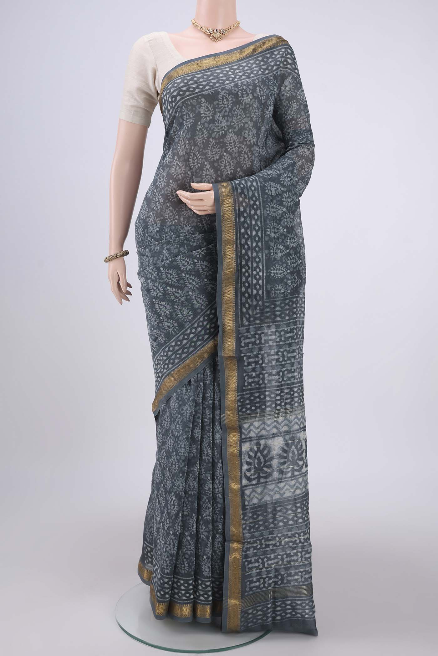 Sage Green Maheshwari Silk Cotton Saree with Batik Print on the body and Zari Border.  displayed on a mannequin