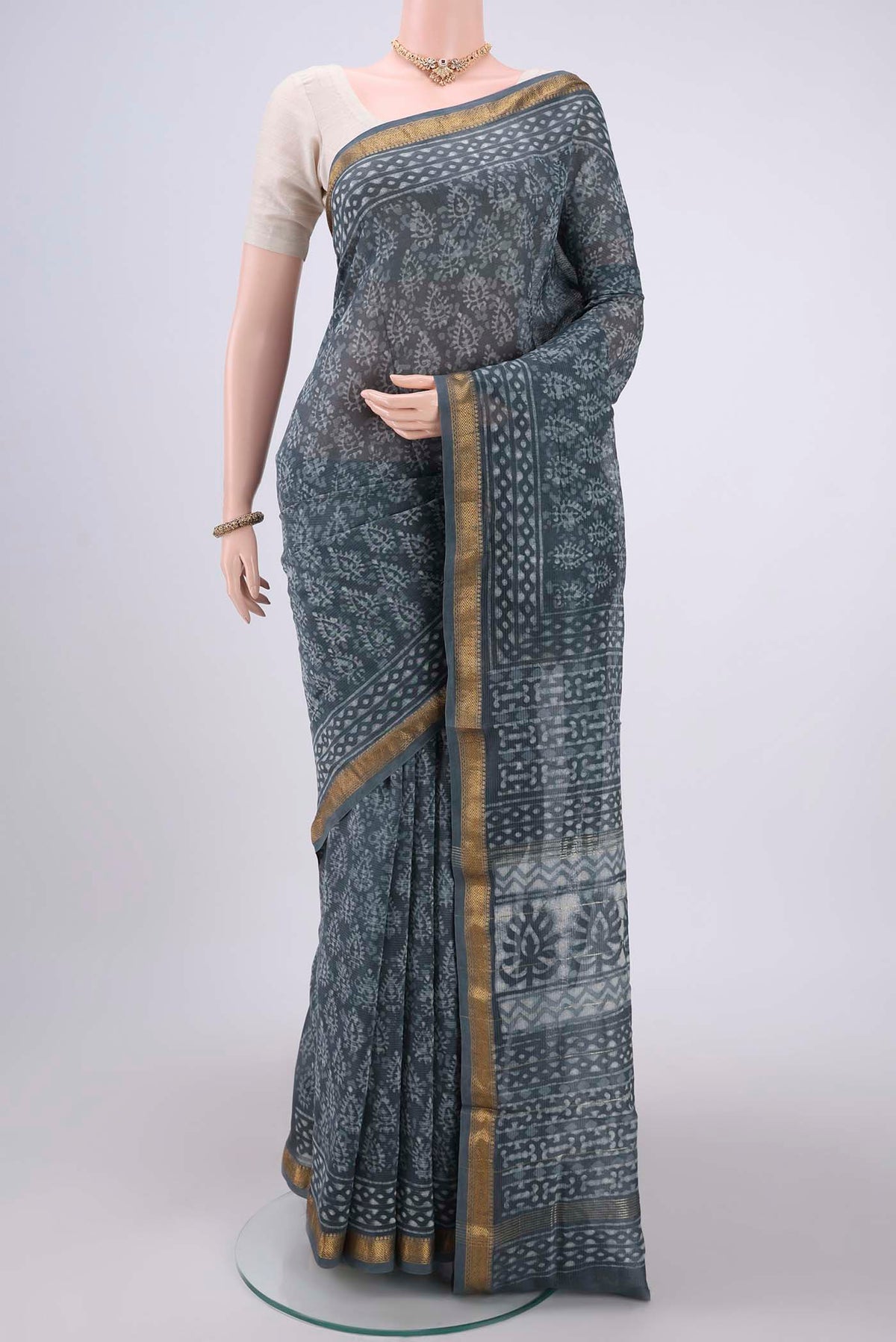 Sage Green Maheshwari Silk Cotton Saree with Batik Print on the body and Zari Border.  displayed on a mannequin