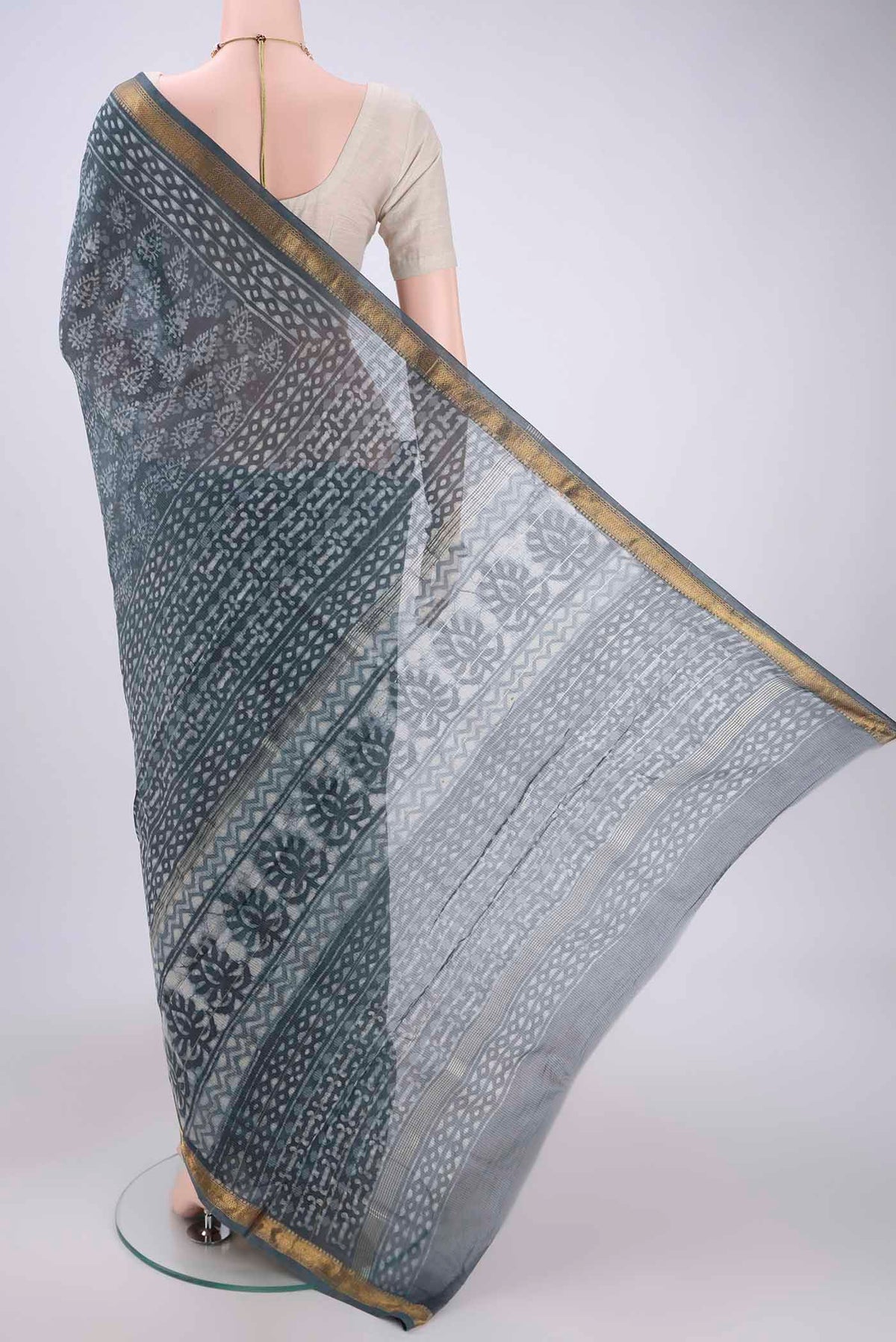 Flat view of Sage Green Maheshwari Silk Cotton Saree with Batik Print on the body and Zari Border. 