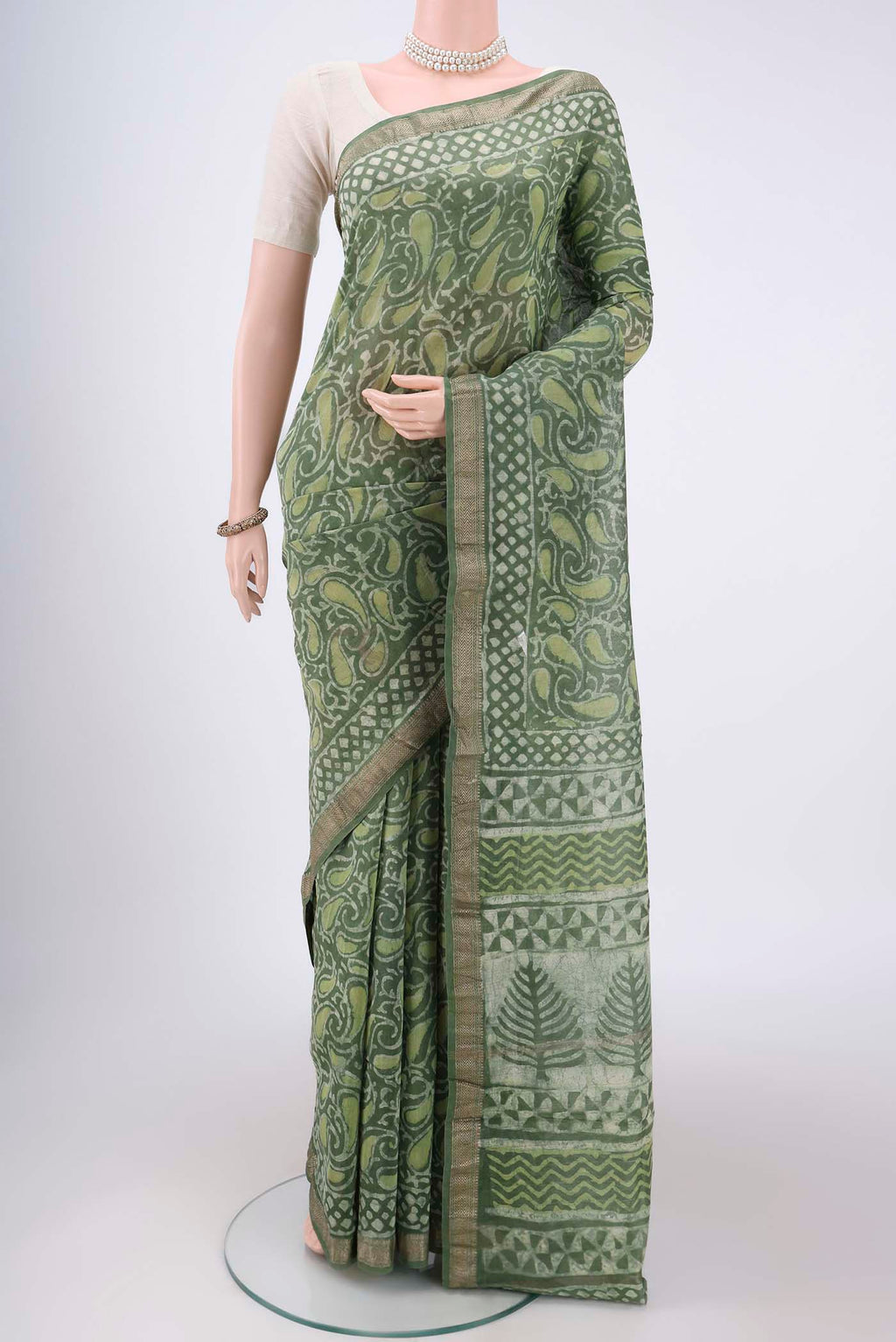 Olive Green Maheshwari Silk Cotton Saree with Batik Print on the body and Zari Border.  displayed on a mannequin