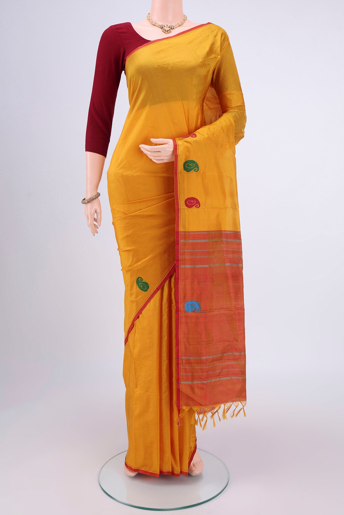 Yellow Kanchipuram Silk Saree with Plain Body and Thread Border.  displayed on a mannequin