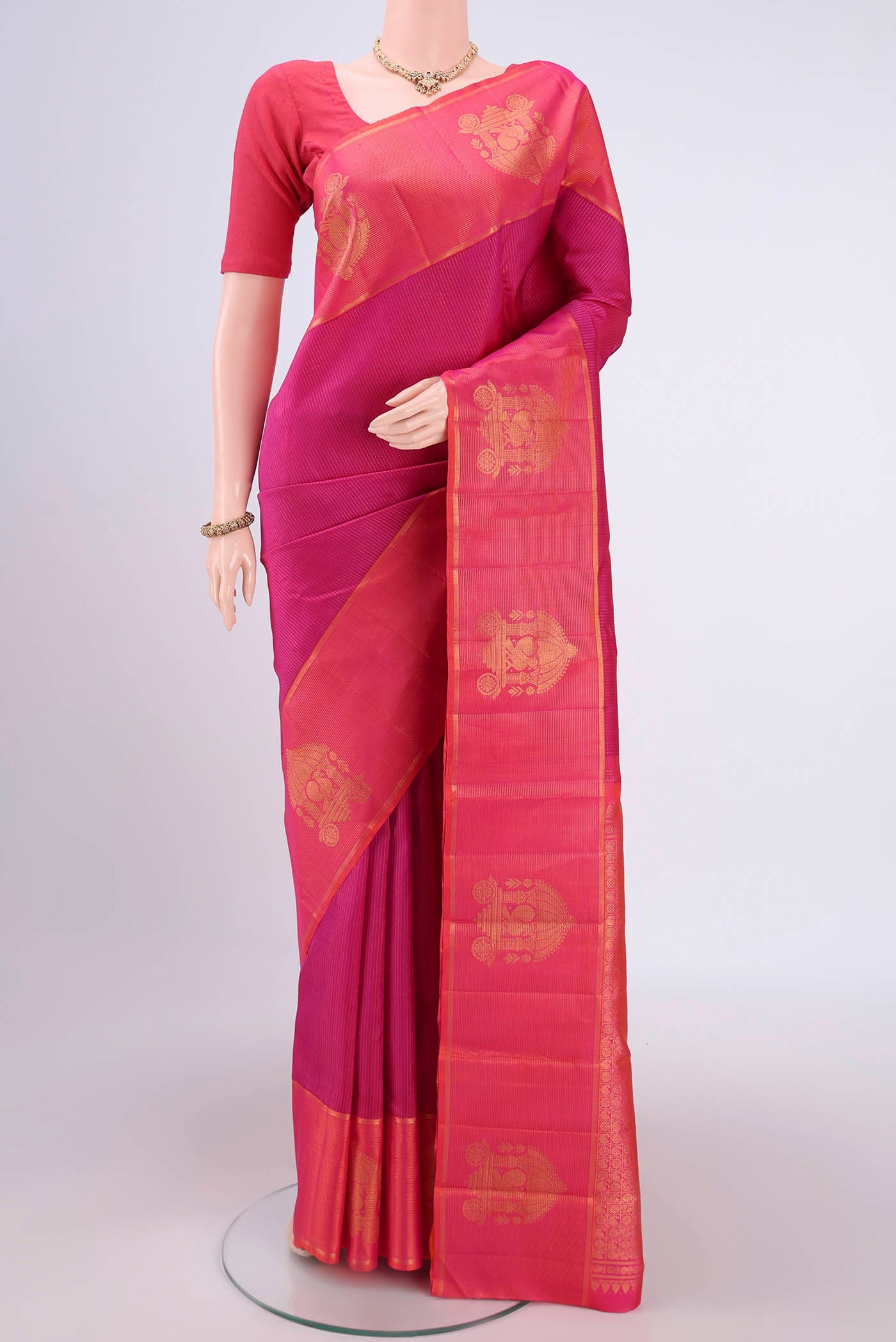 Dark Pink Kanjivaram Silk Saree with Stripes on the body and Zari Border.  displayed on a mannequin
