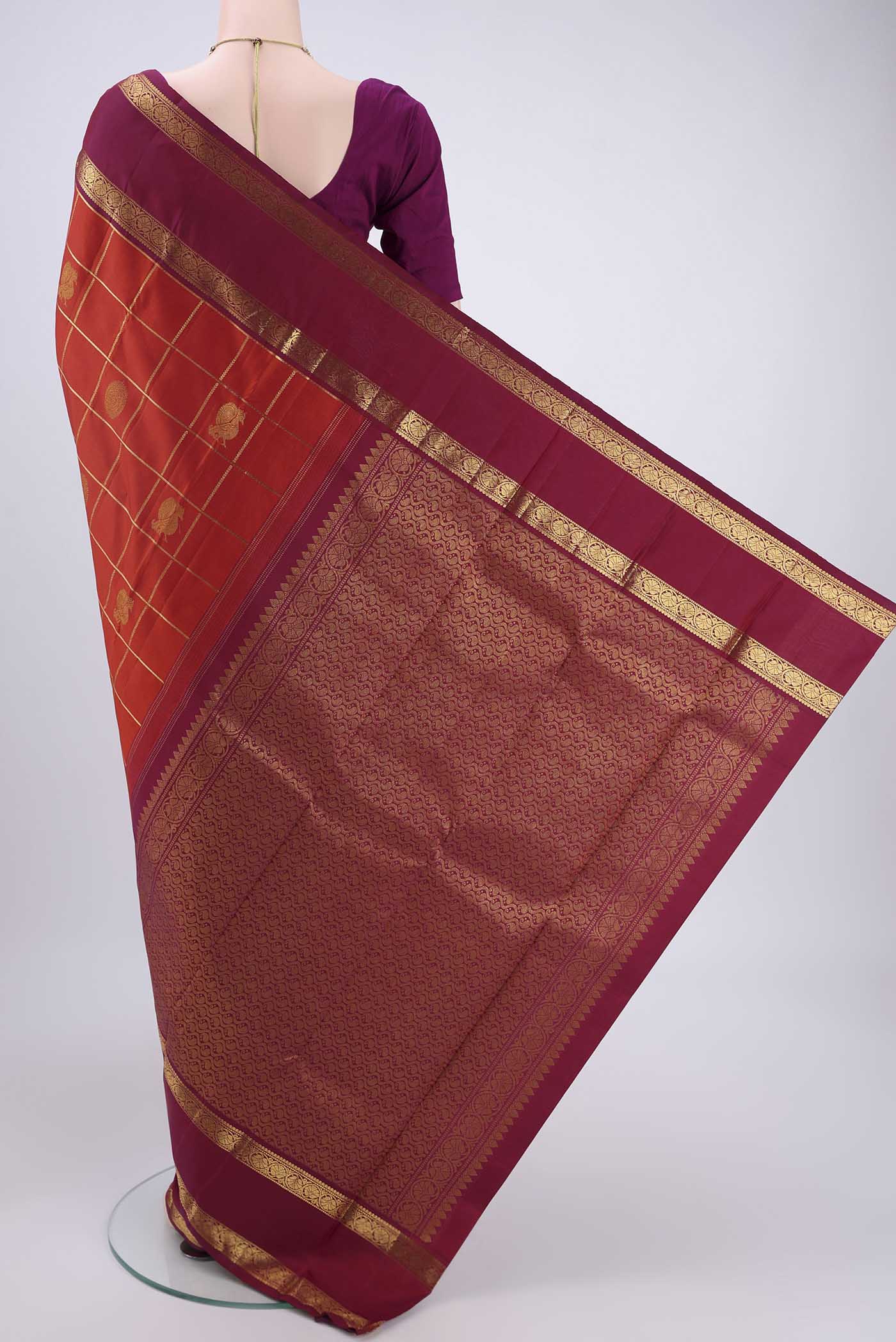 Flat view of Rust Kanjivaram Silk Saree with Checked design on the body and Zari Border. 