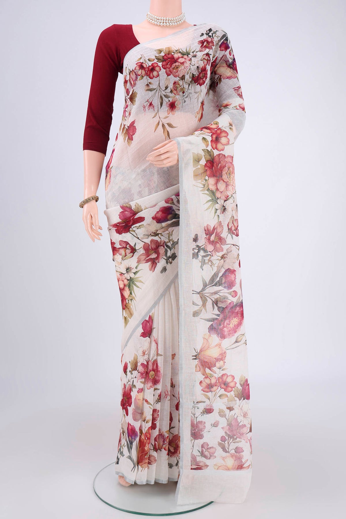 Off White Linen Saree with Floral Print on the body and Zari Border.  displayed on a mannequin
