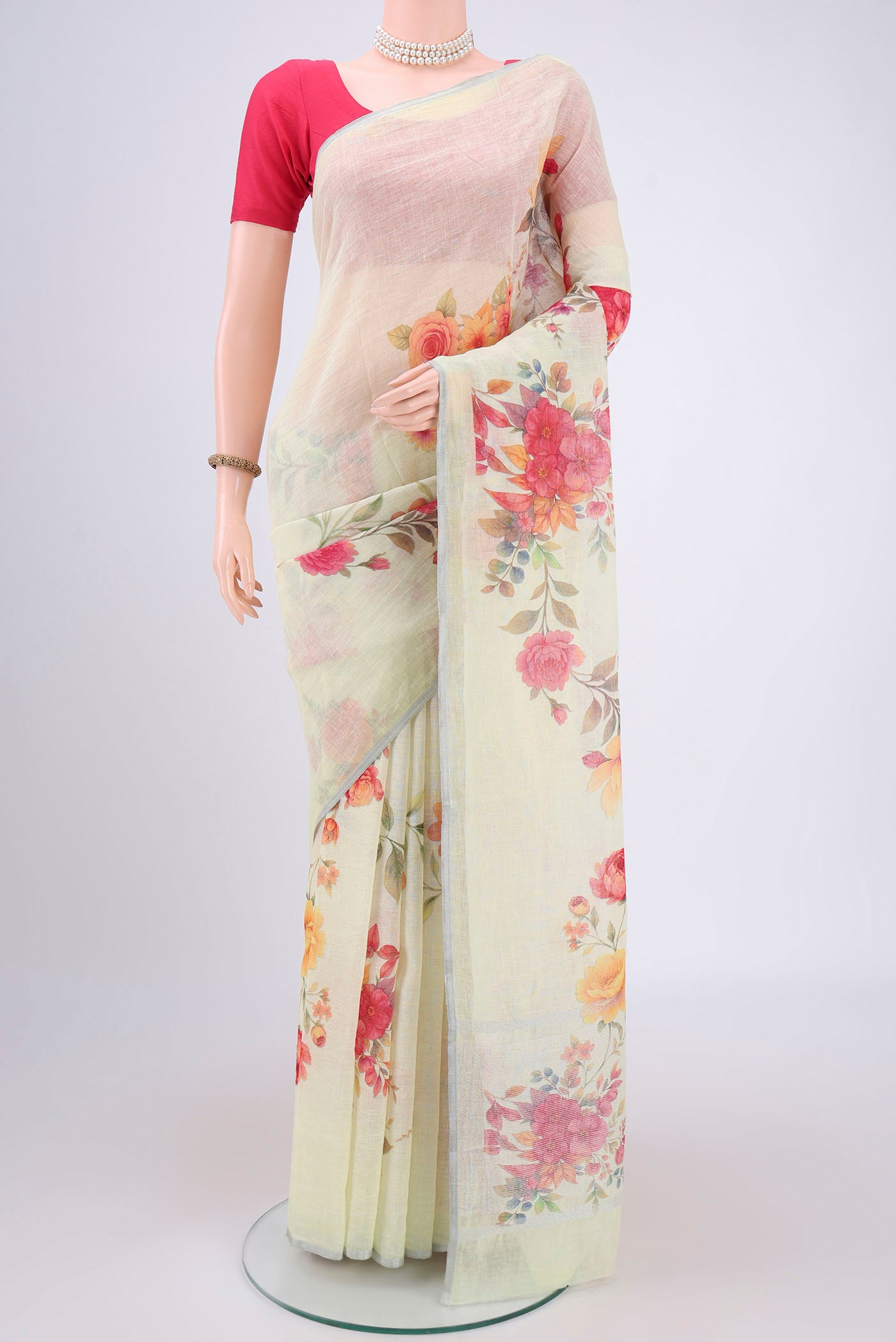 Mint Green Linen Saree with Floral Print on the body and Zari Border.  displayed on a mannequin