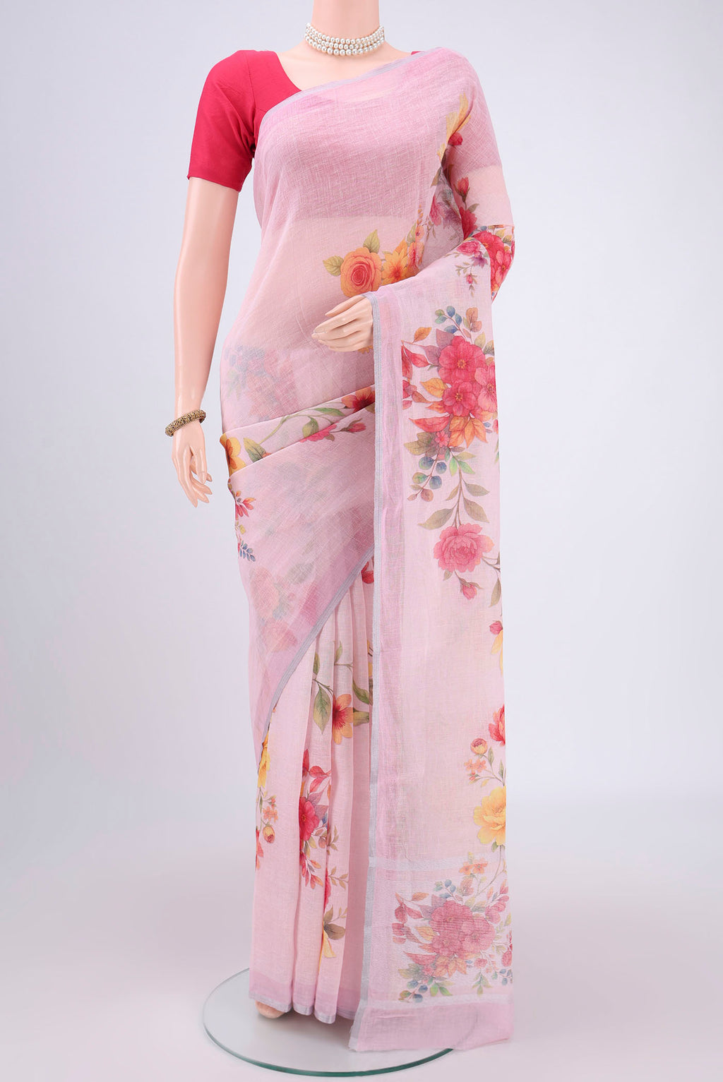 Pink Linen Saree with Floral Print on the body and Zari Border.  displayed on a mannequin
