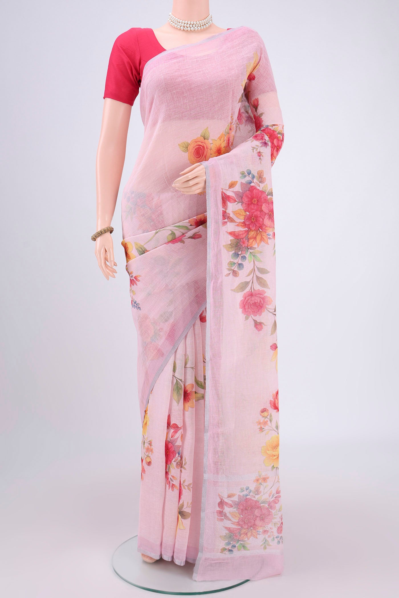 Pink Linen Saree with Floral Print on the body and Zari Border.  displayed on a mannequin