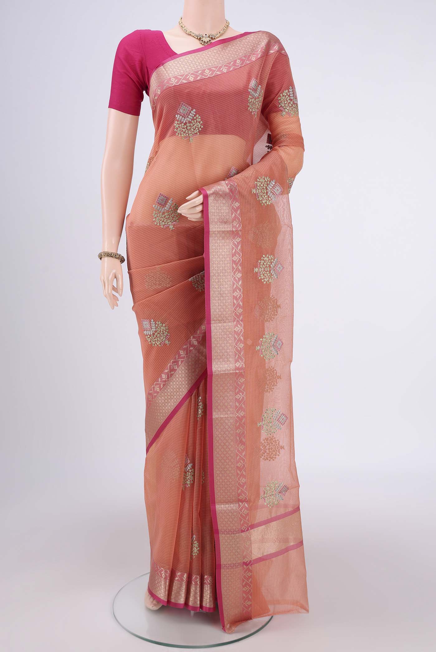 Peach Kota Silk Saree with Embroidery on the body and Plain Border.  displayed on a mannequin