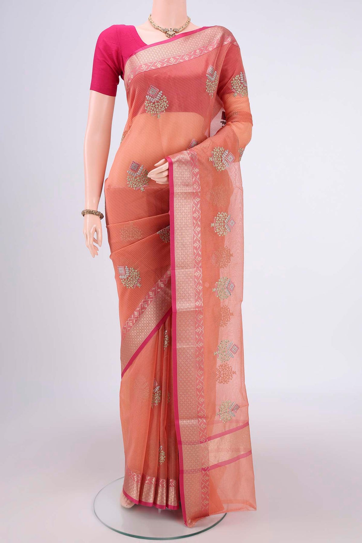 Peach Kota Silk Saree with Embroidery on the body and Plain Border.  displayed on a mannequin