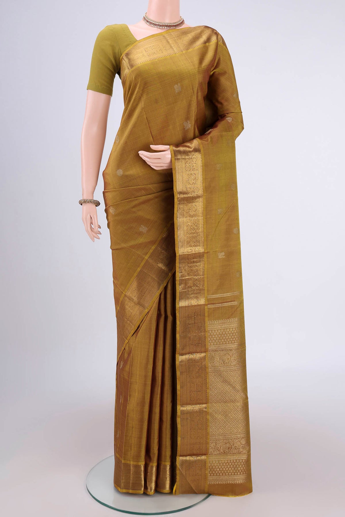 Pure Silk Pure Zari Mehandi Green Kanjivaram Saree with Zari Butta on the body and Zari Border.  displayed on a mannequin