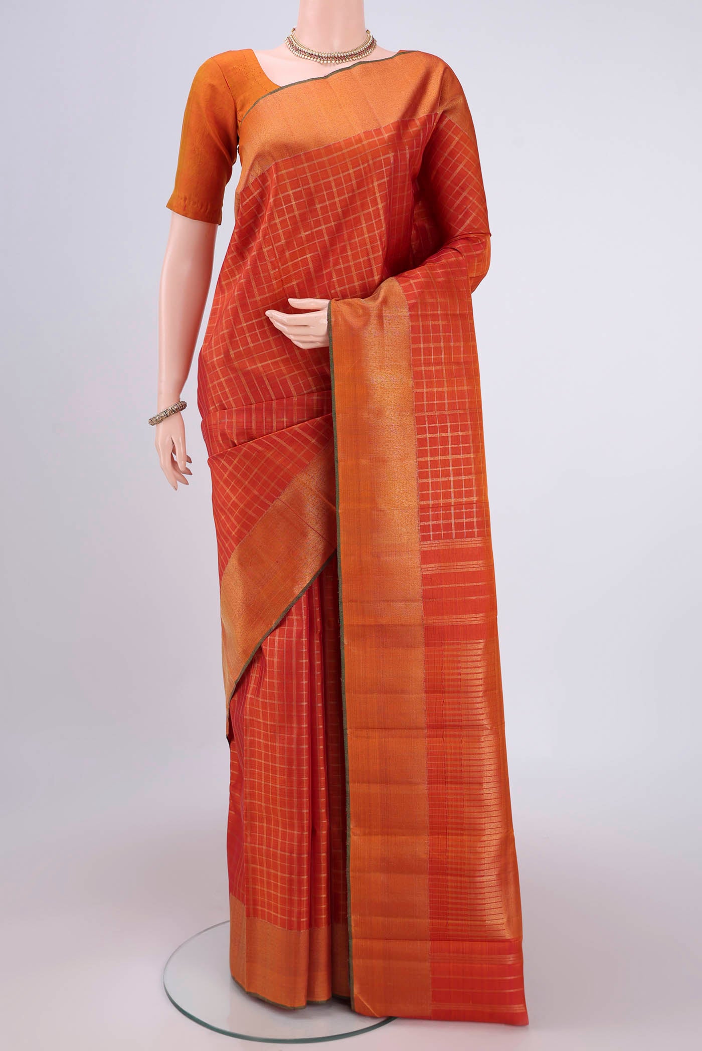 Pure Silk Pure Zari Rust Kanjivaram Saree with Checked design on the body and Zari Border.  displayed on a mannequin