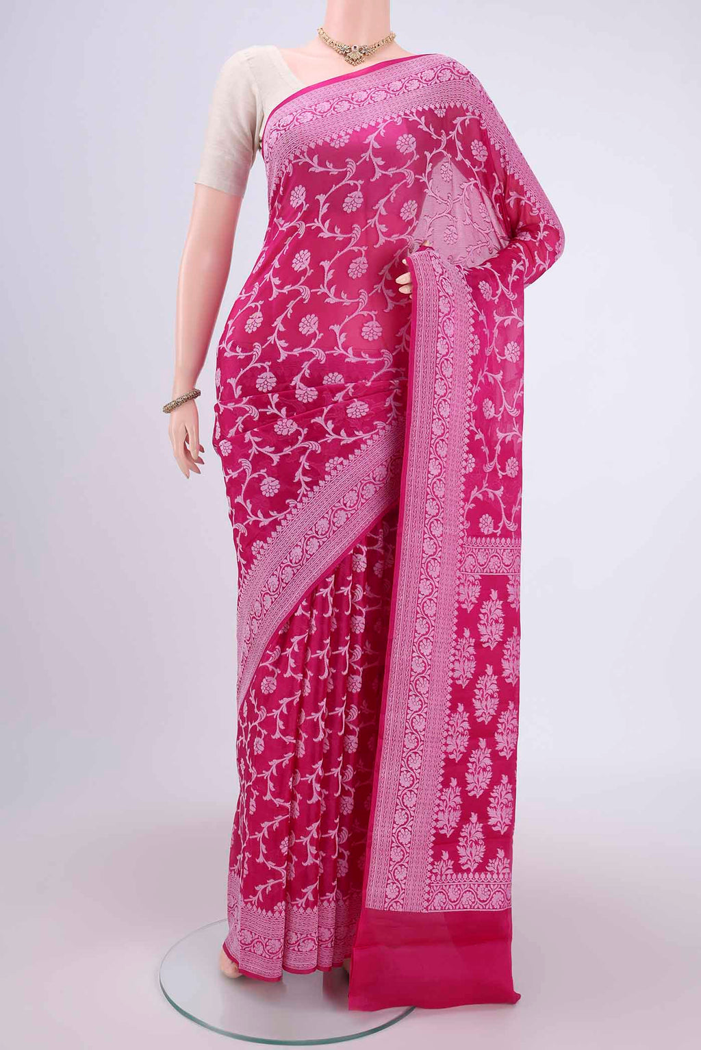 Rani Pink Blended Banarasi Georgette Saree with Thread Brocade on the body and Zari Border.  displayed on a mannequin