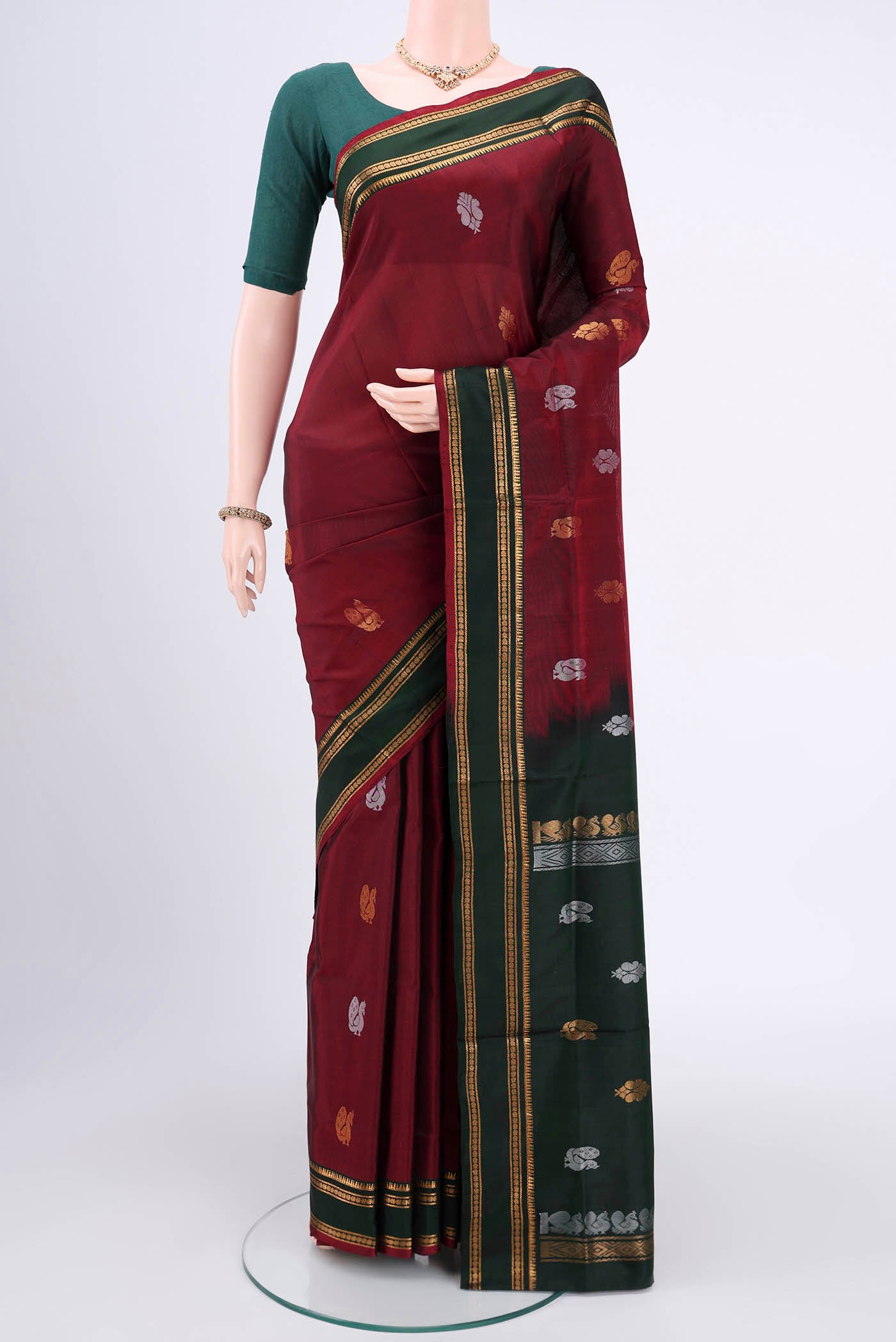 Maroon Uppada Silk Saree with Zari Butta on the body and Zari Border.  displayed on a mannequin