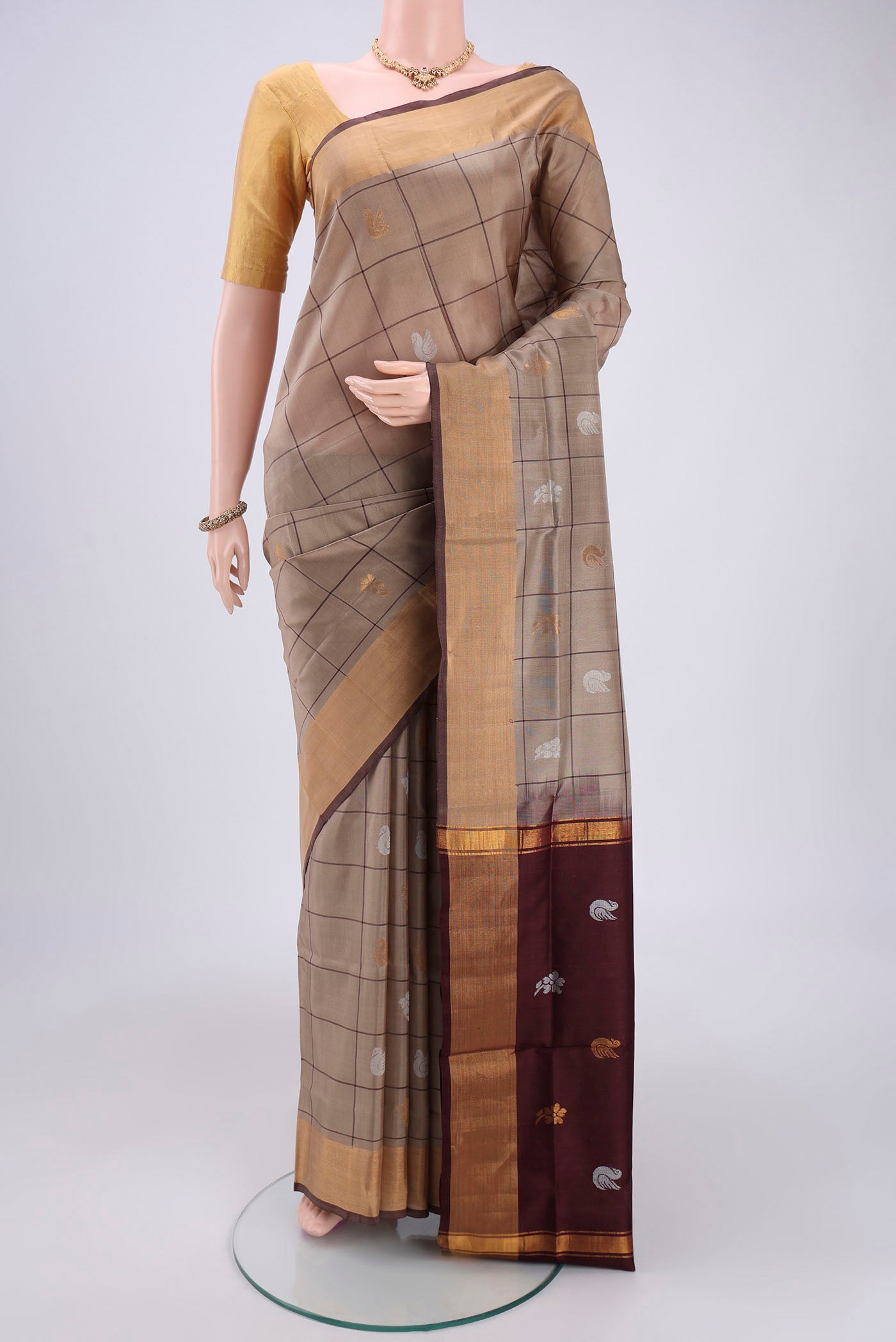 Dark Beige Uppada Silk Saree with Checked design on the body and Zari Border.  displayed on a mannequin