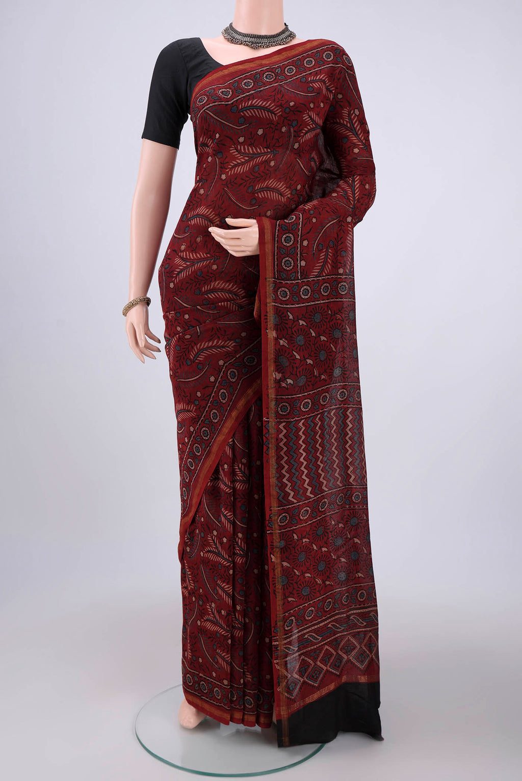 Maroon Chanderi Silk Cotton Saree with Ajrakh Print on the body and Zari Border.  displayed on a mannequin