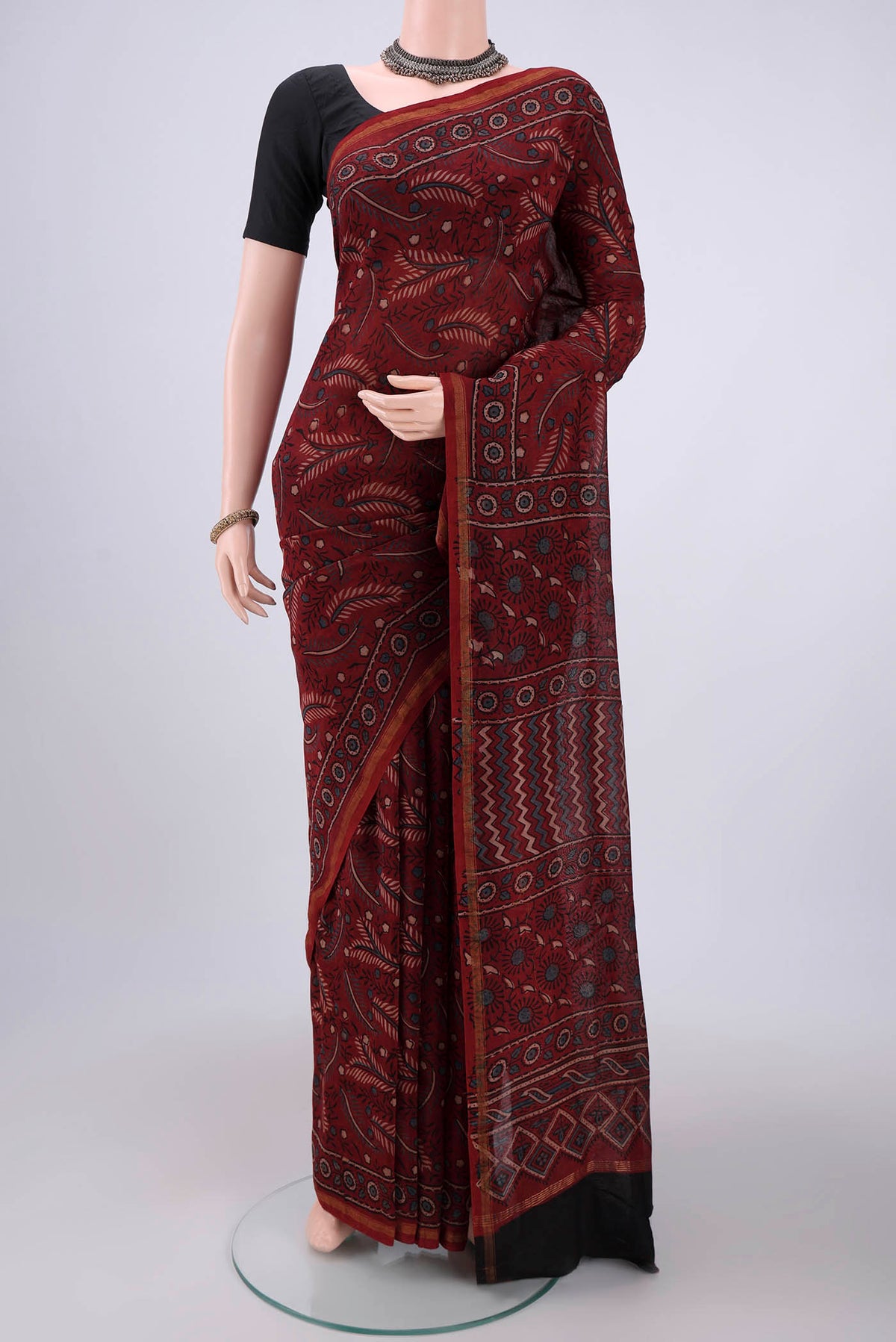 Maroon Chanderi Silk Cotton Saree with Ajrakh Print on the body and Zari Border.  displayed on a mannequin