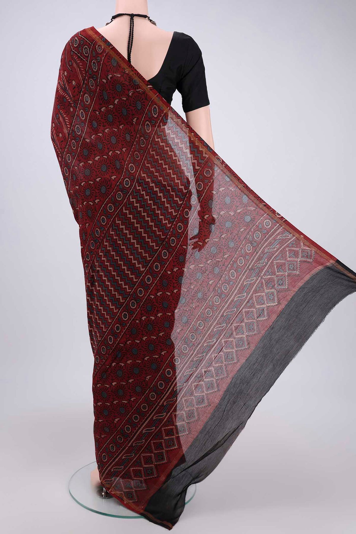 Flat view of Maroon Chanderi Silk Cotton Saree with Ajrakh Print on the body and Zari Border. 