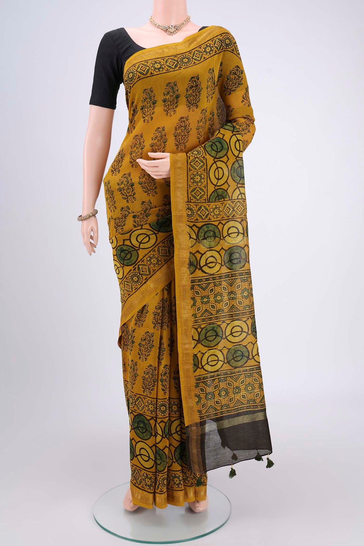 Mustard Chanderi Silk Cotton Saree with Ajrakh Print on the body and Zari Border.  displayed on a mannequin
