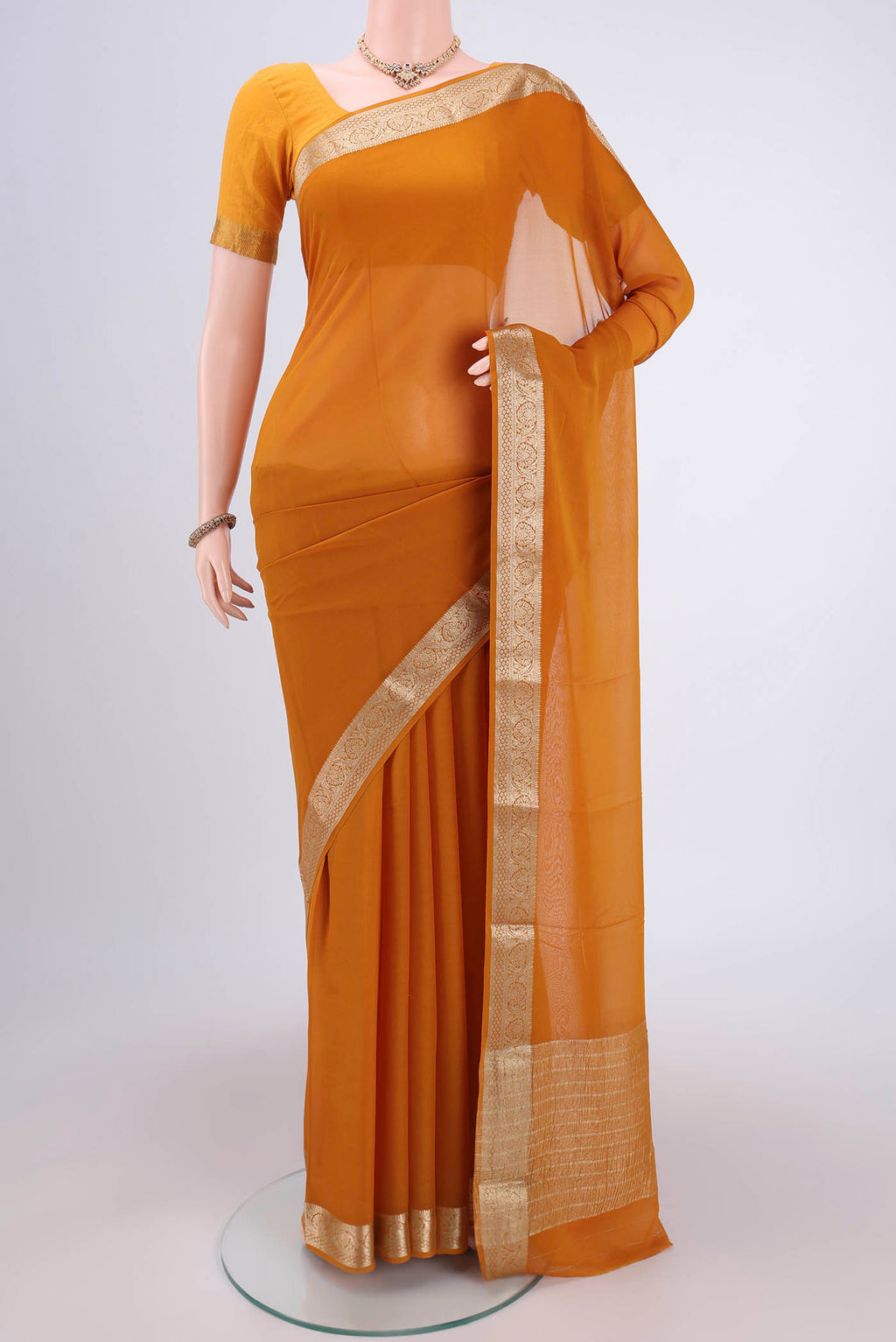 Mustard Georgette Saree with Plain Body and Satin Border.  displayed on a mannequin
