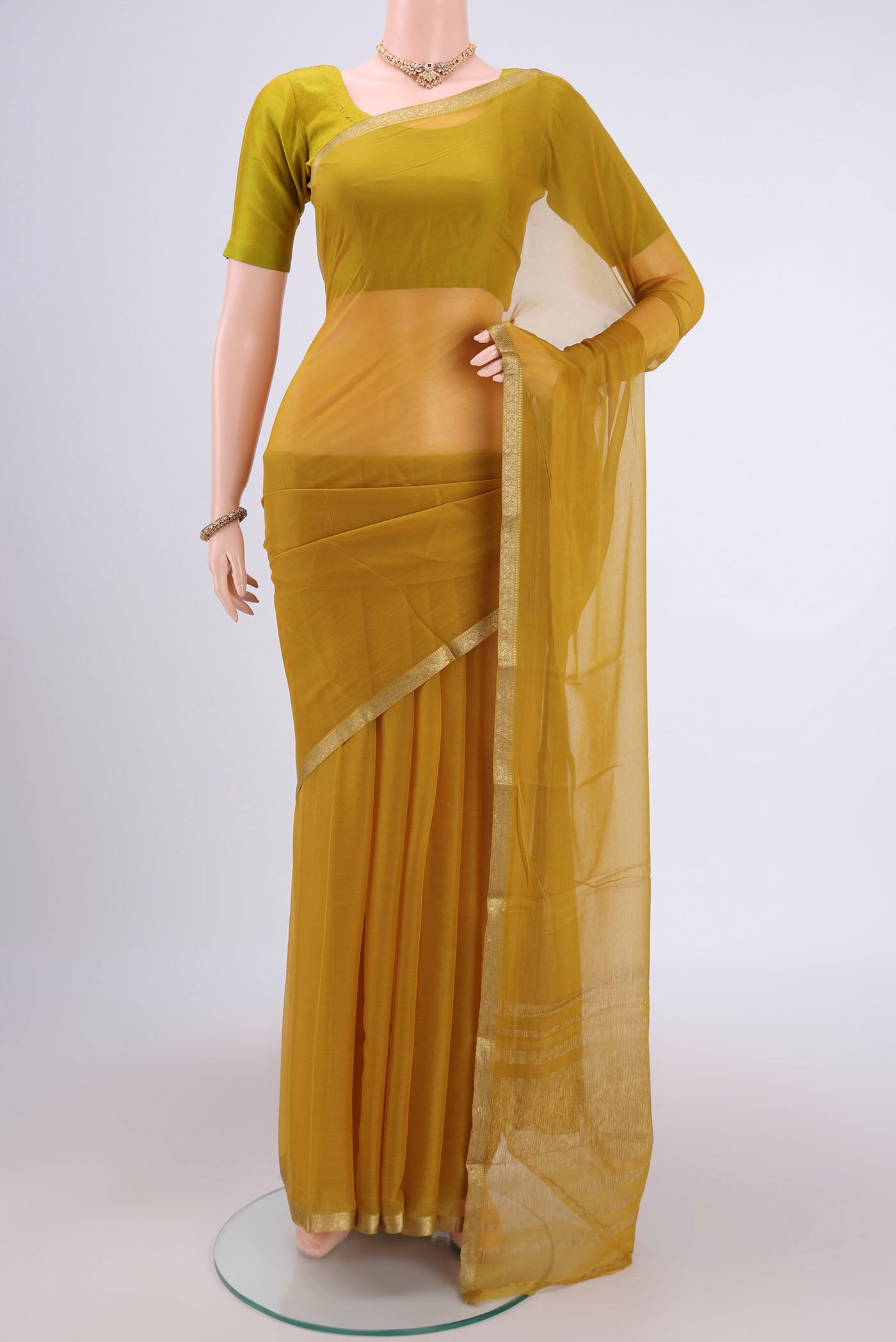 Mehandi Green Mysore Chiffon Saree with Plain Body and Zari Border.  displayed on a mannequin