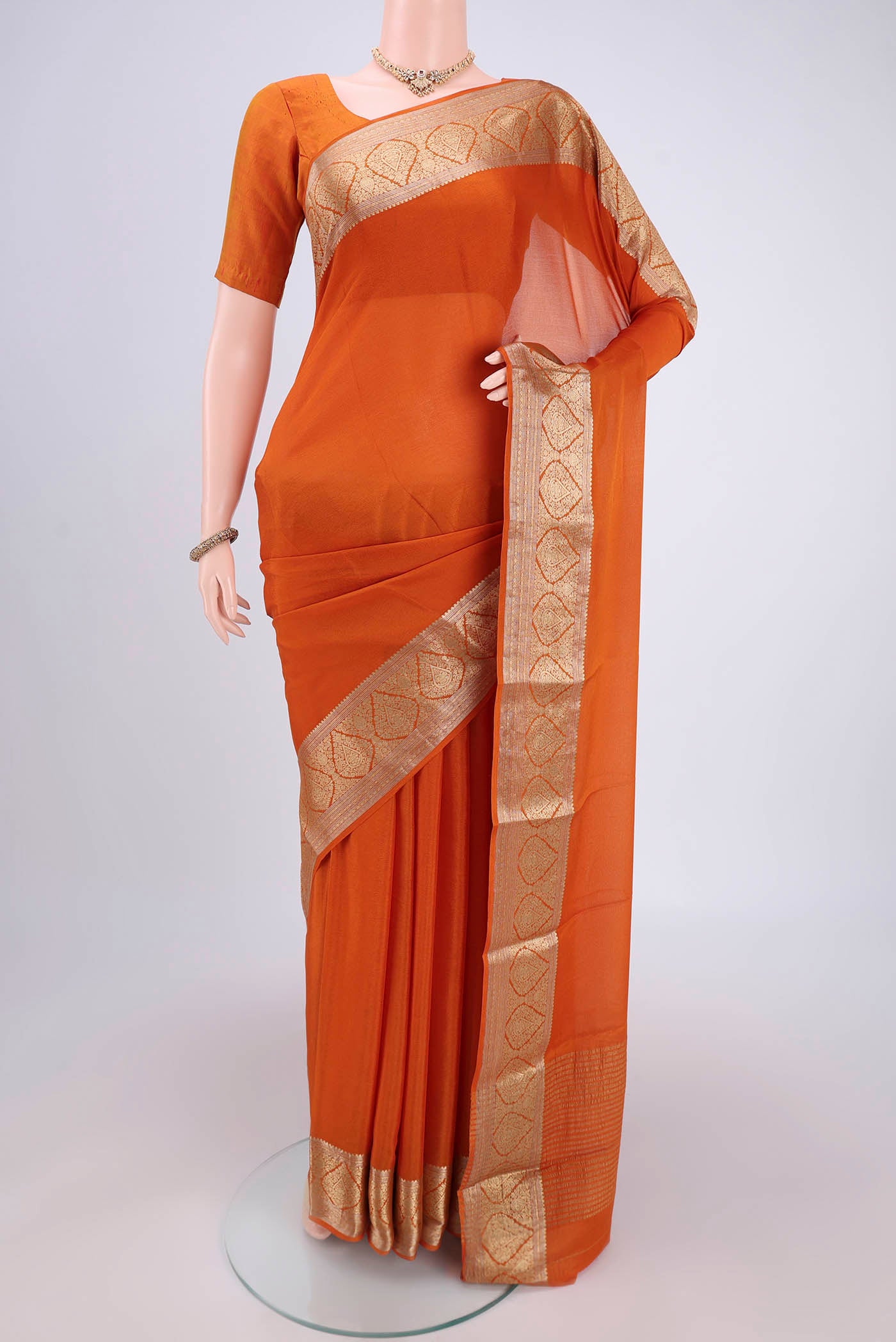 Rust Mysore Chiffon Saree with Plain Body and Zari Border.  displayed on a mannequin