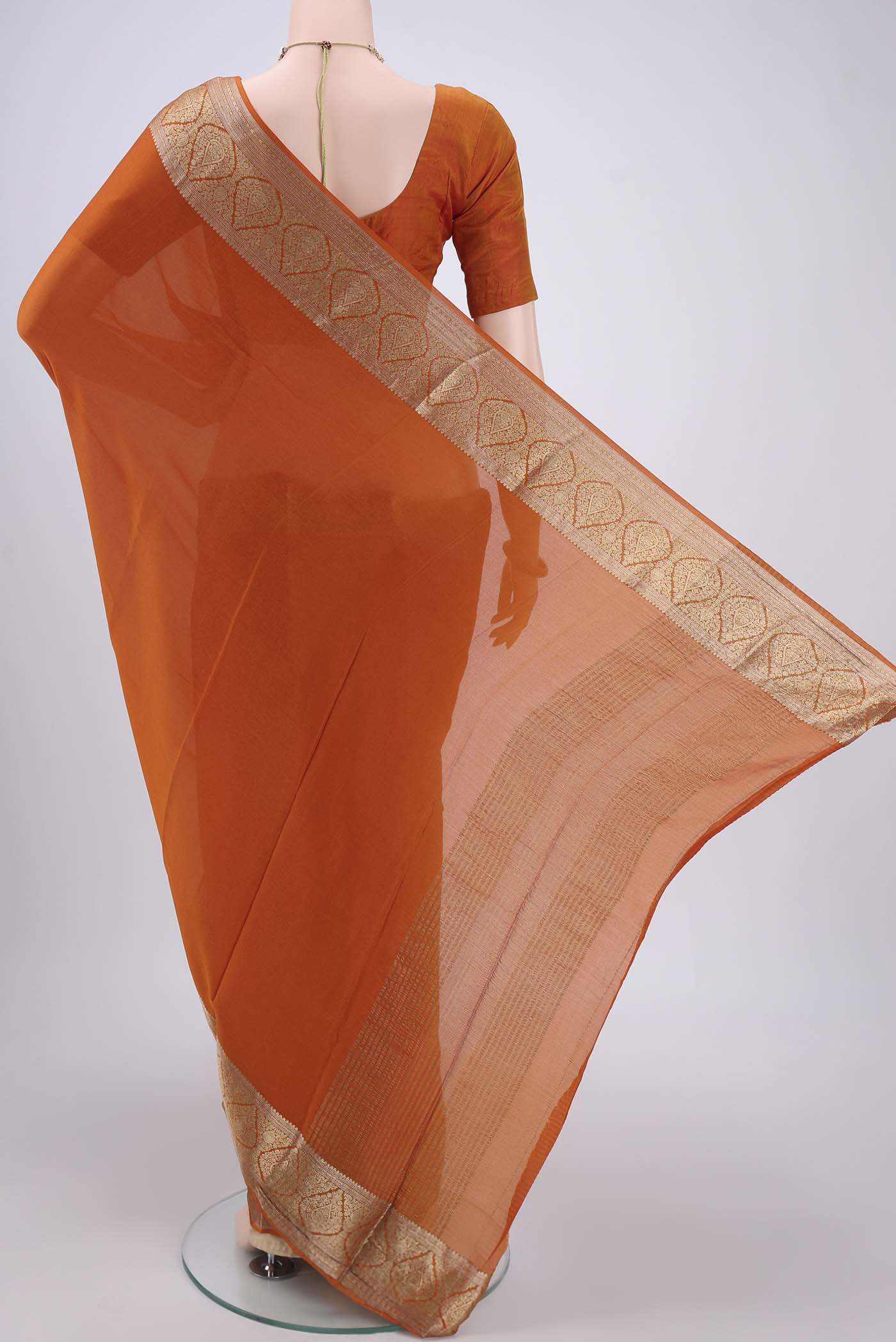 Flat view of Rust Mysore Chiffon Saree with Plain Body and Zari Border. 
